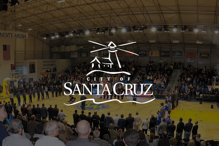 Crowd gathered inside a sports arena with a basketball court, with a large logo of the City of Santa Cruz overlayed on the image.