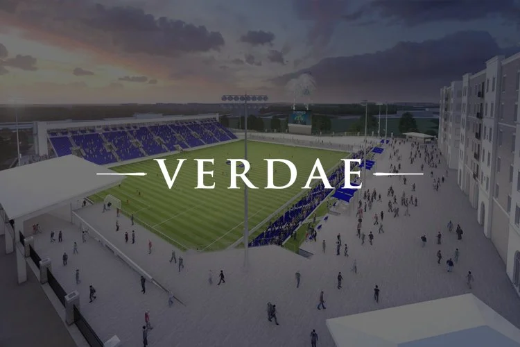 A digital rendering of a stadium with a soccer field, surrounded by spectators and buildings, with a cloudy sky in the background, and the logo 'VERDAE' overlaid.
