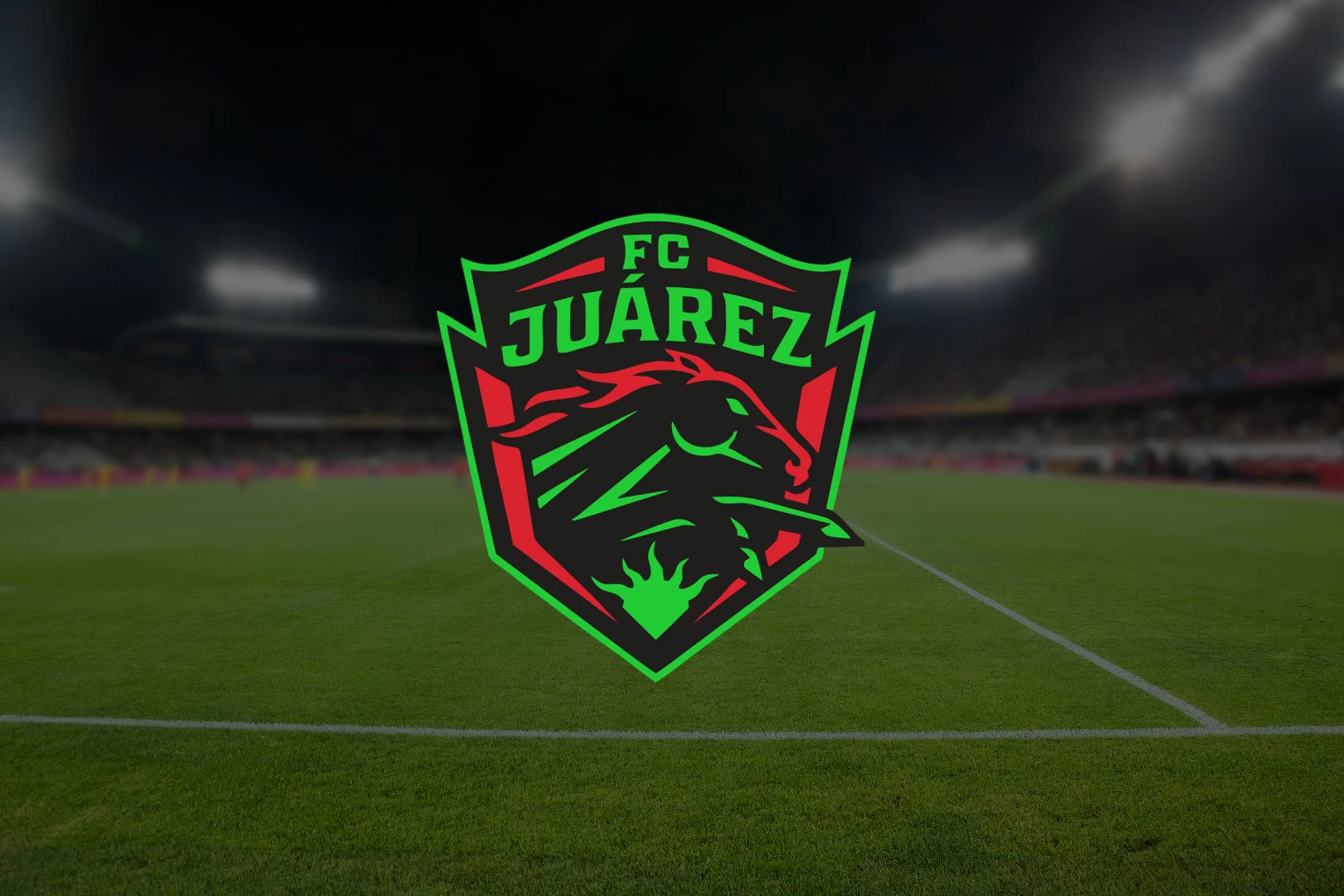 Logo of FC Juárez, a Mexican soccer team, superimposed over a soccer stadium field at night.