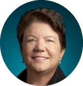 Portrait of a woman with short dark hair, smiling, against a teal background.