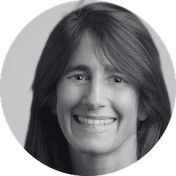 A woman smiling at the camera in a black-and-white photo.