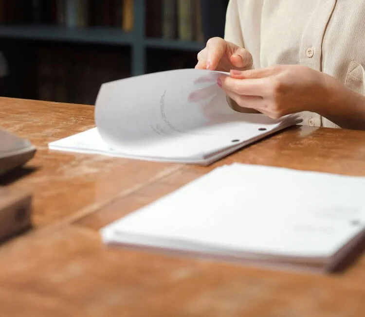 Person reviewing printed documents at a desk.