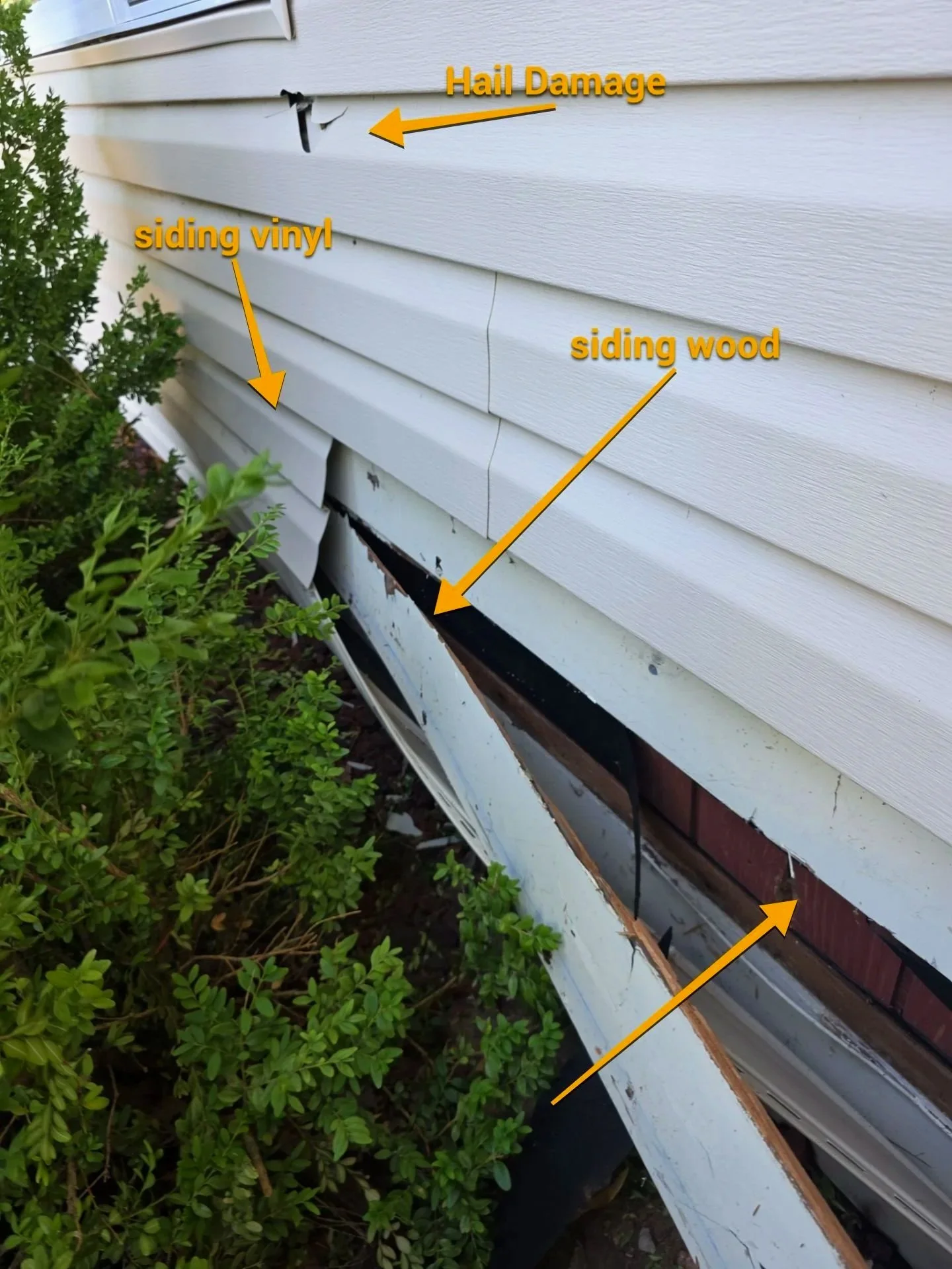 Siding damage on the exterior of a house, with siding vinyl and siding wood panels, showing a hole and cracks in the siding, caused by hail damage.