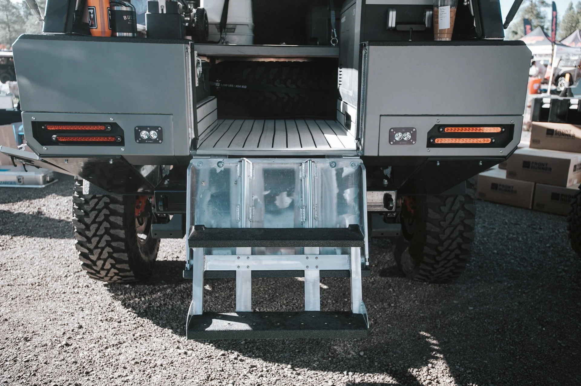 View of the rear of an off-road utility vehicle with a metal ladder and steps for access.