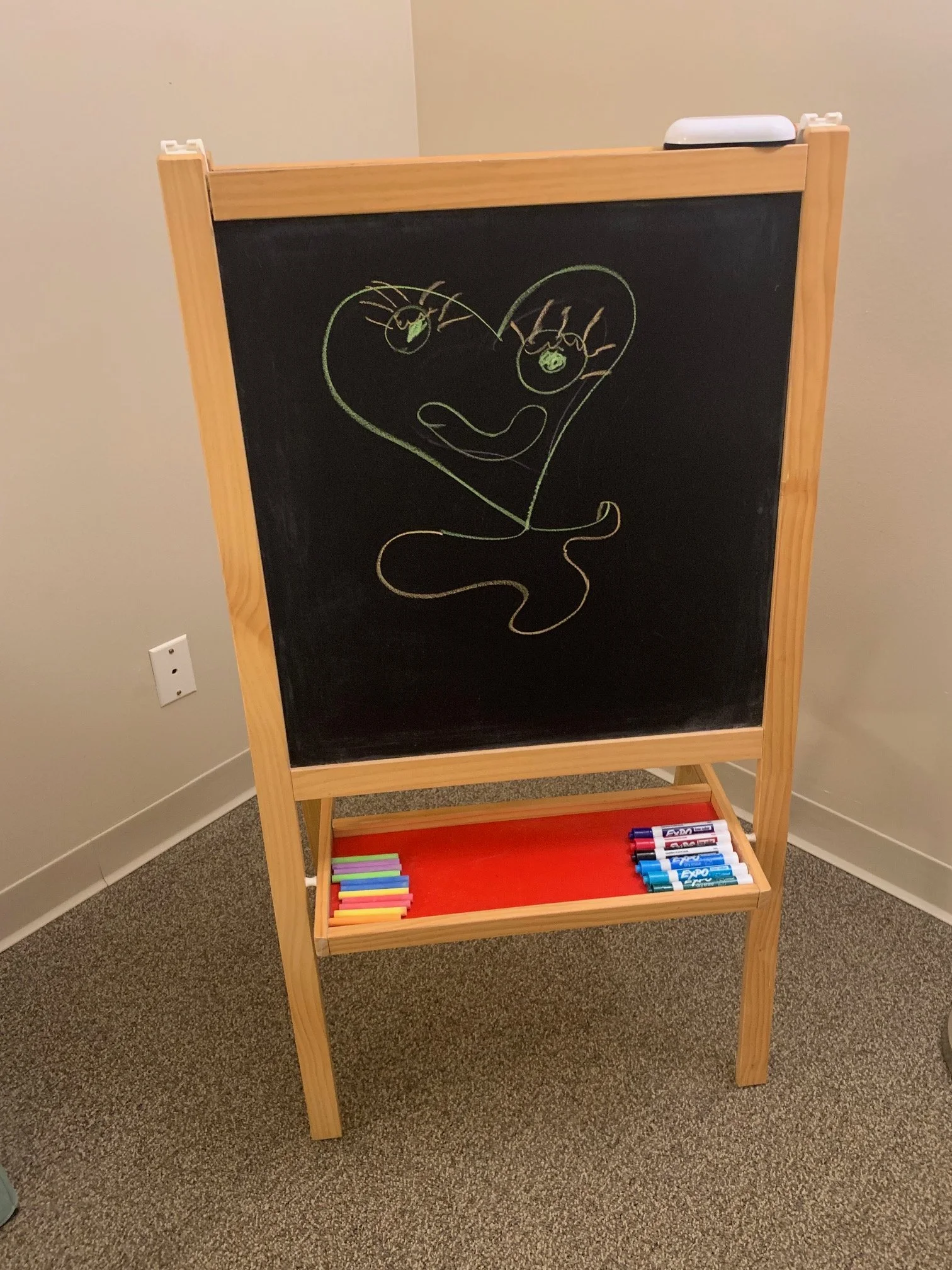My daughter's original artwork on the chalkboard. Dry erase board on the other side.