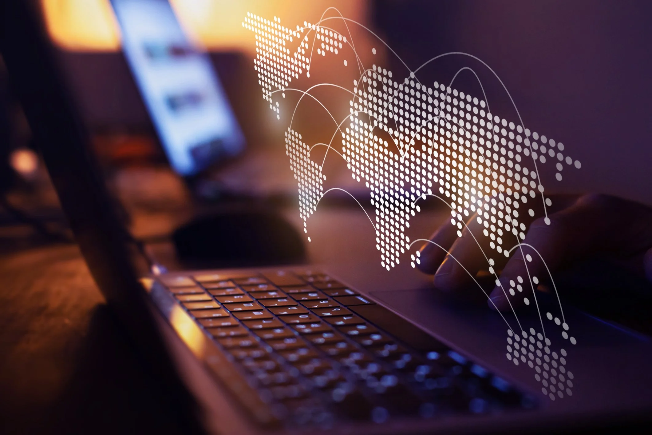 A person using a laptop with a digital overlay of a world map and network lines, symbolizing global data and connectivity.