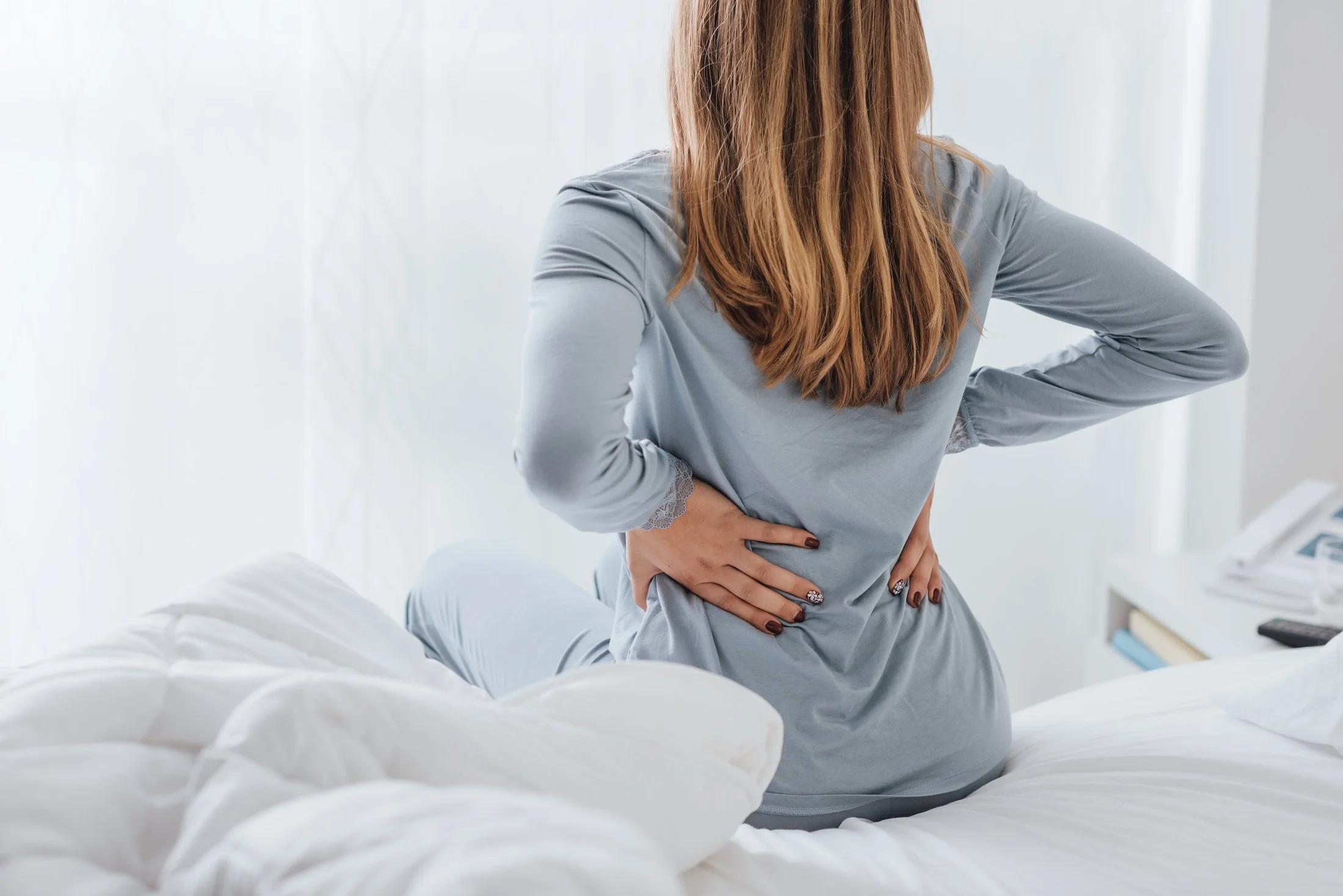 Woman experiencing back pain seeking PT in Encinitas