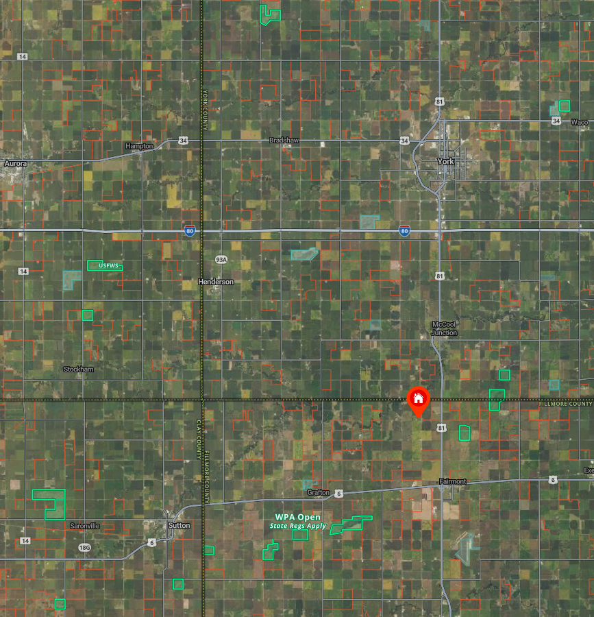 Satellite map of rural area with roads, property boundaries, water bodies, and a house icon indicating a specific location.