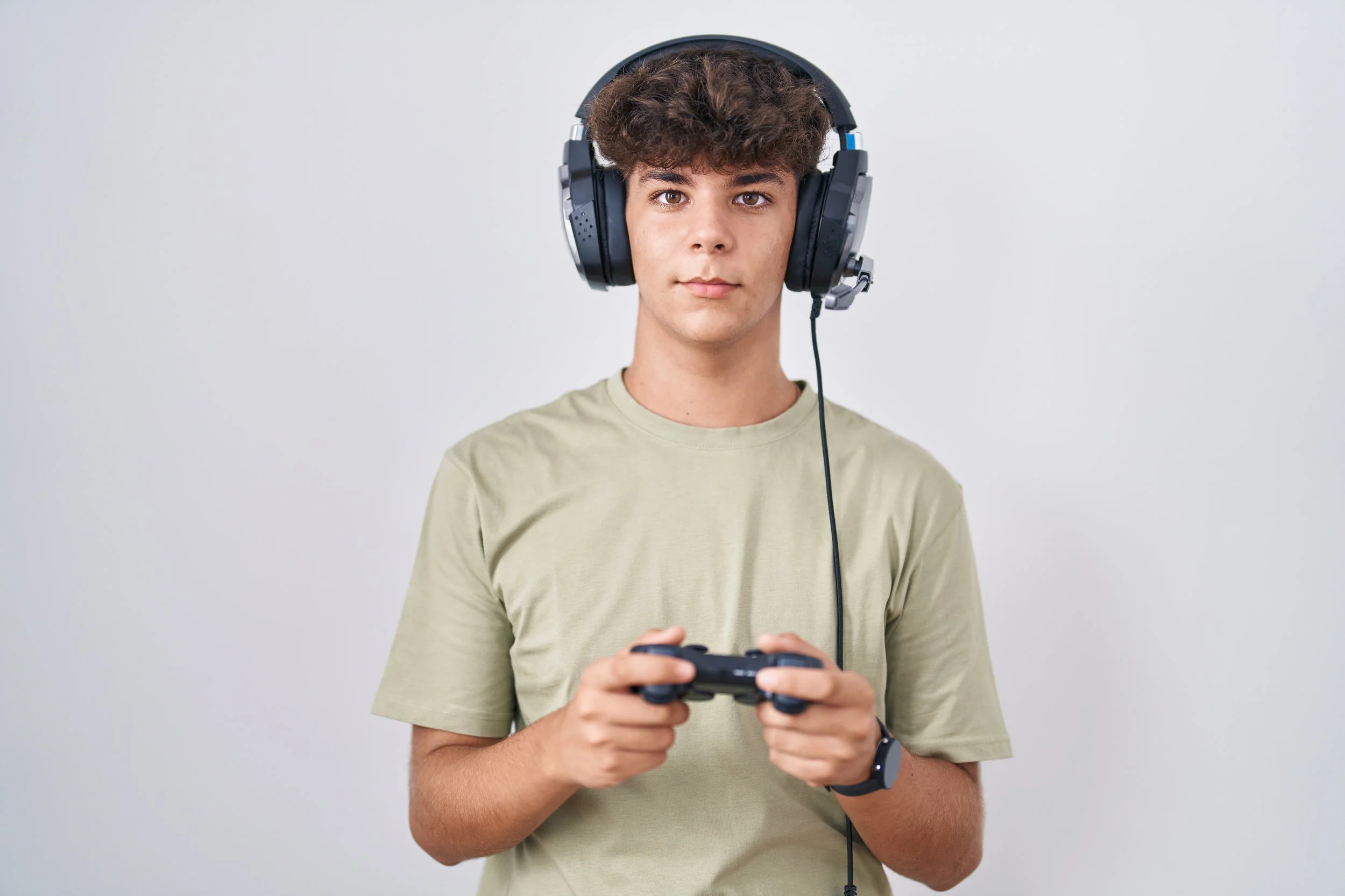 A man wearing a headphones and using a controller for gaming - Calm Harbor Counseling