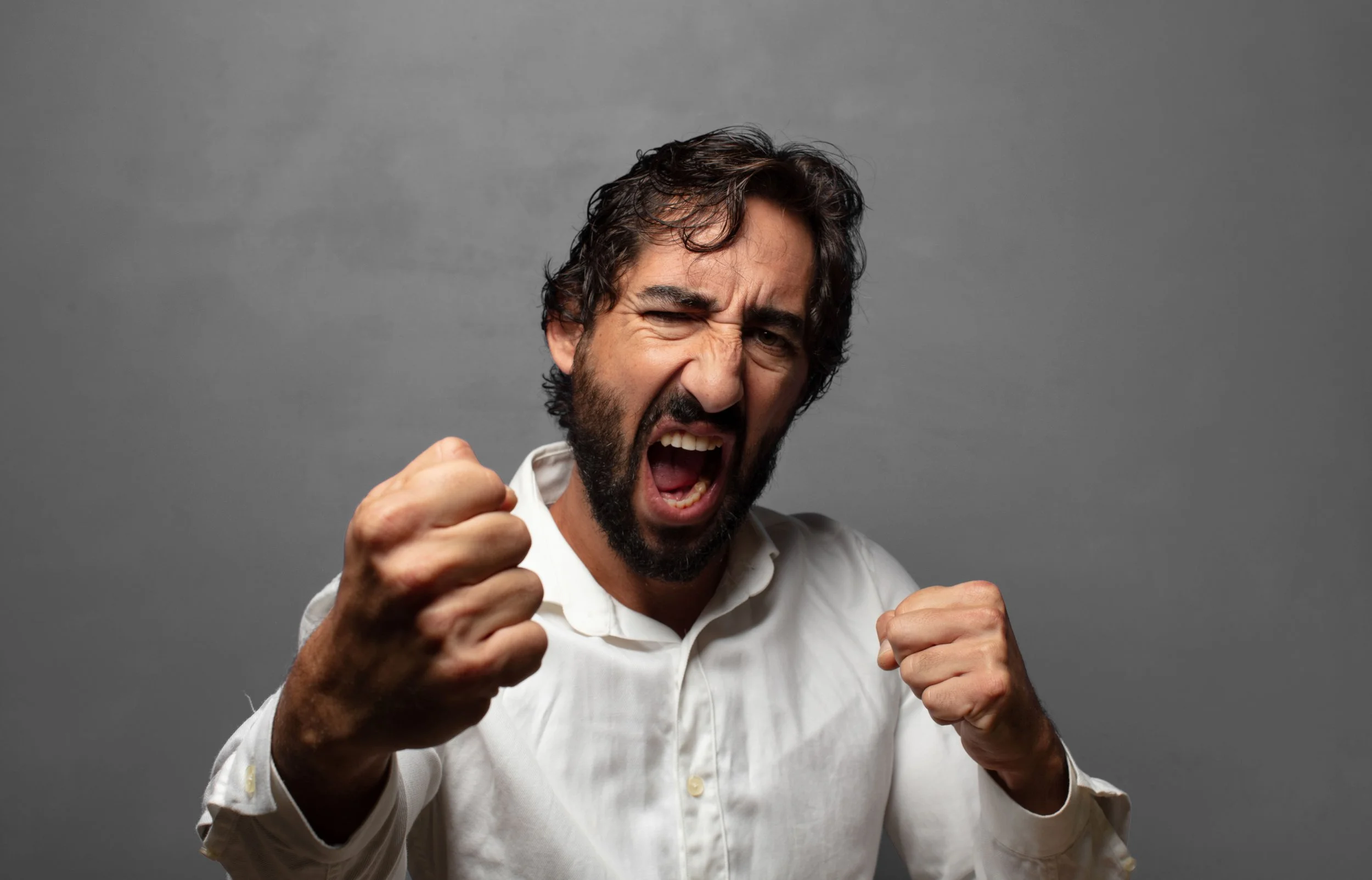 A man with his fists up, indicating that he is aggressive - Calm Harbor Counseling