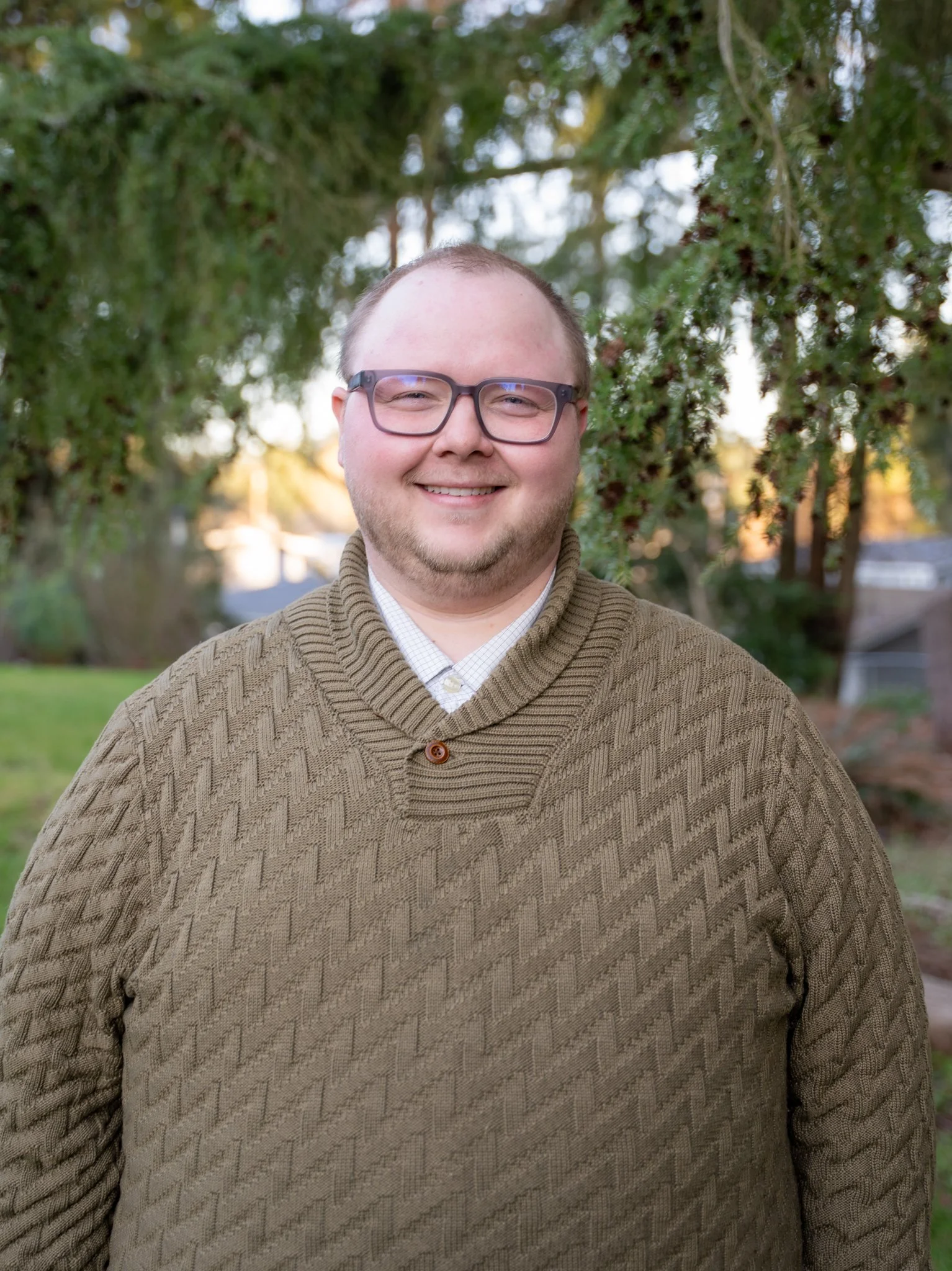 Dr. Tyler Ellis, a smiling man in glasses who is an audiologist who co-founded Harmony Audiology in Mountlake Terrace, Washington.