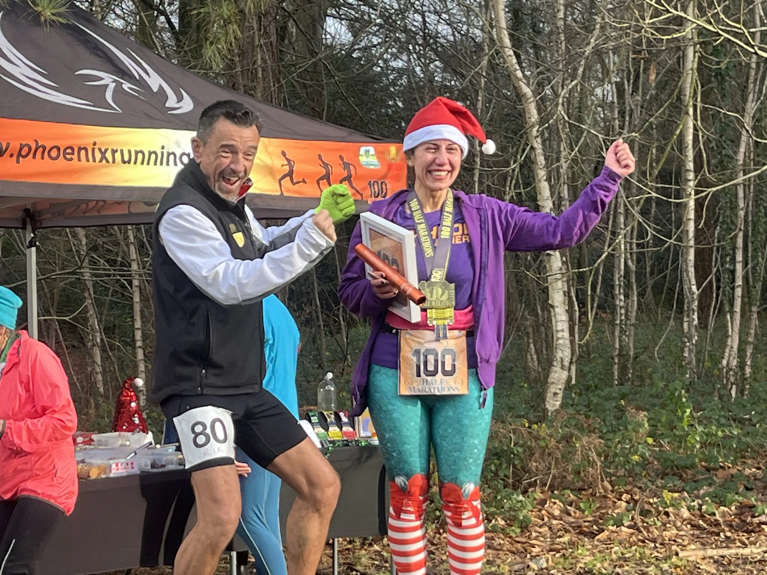 Zerrin receiving her official certificate and banner for her 100th 1/2 marathon