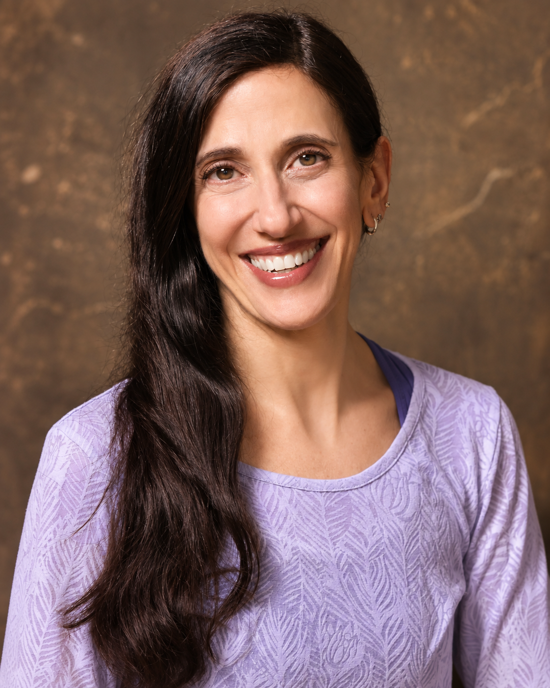 Lisa Reese smiling, wearing a lavender top, with long dark hair over one shoulder.
