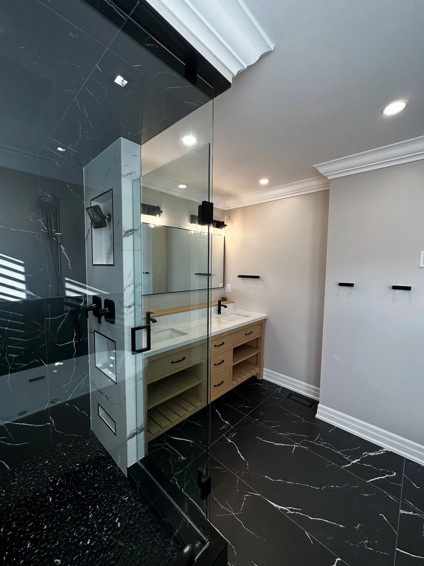 Before ➡️ After
From dated and ordinary to a true spa-like retreat.

This remodel features:
✔️ Freestanding tub with relaxing spa vibes
✔️ Sleek black marble-look flooring
✔️ Custom double vanity with wood tones for warmth
✔️ Frameless glass shower w