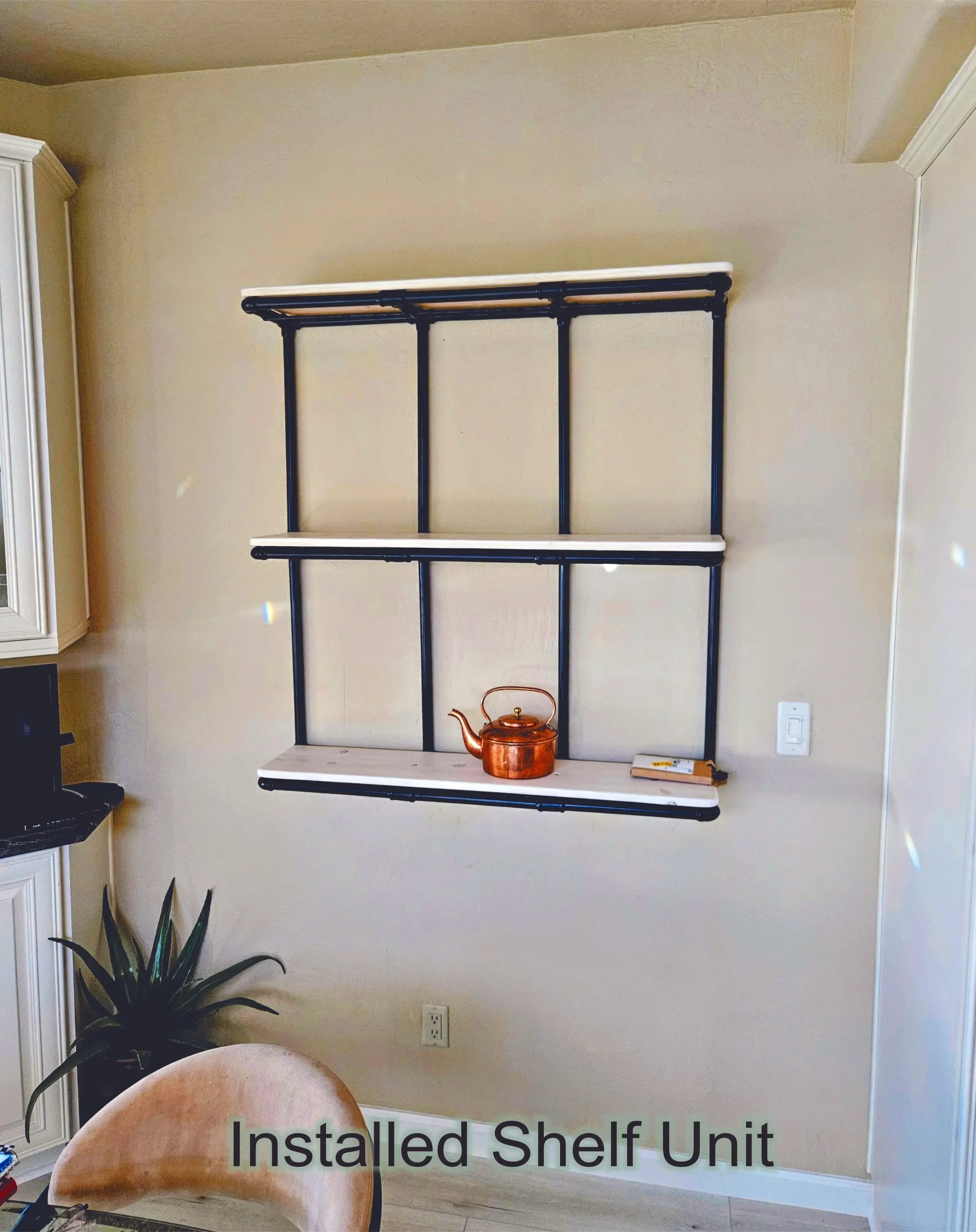 Finished black pipe shelf on wall