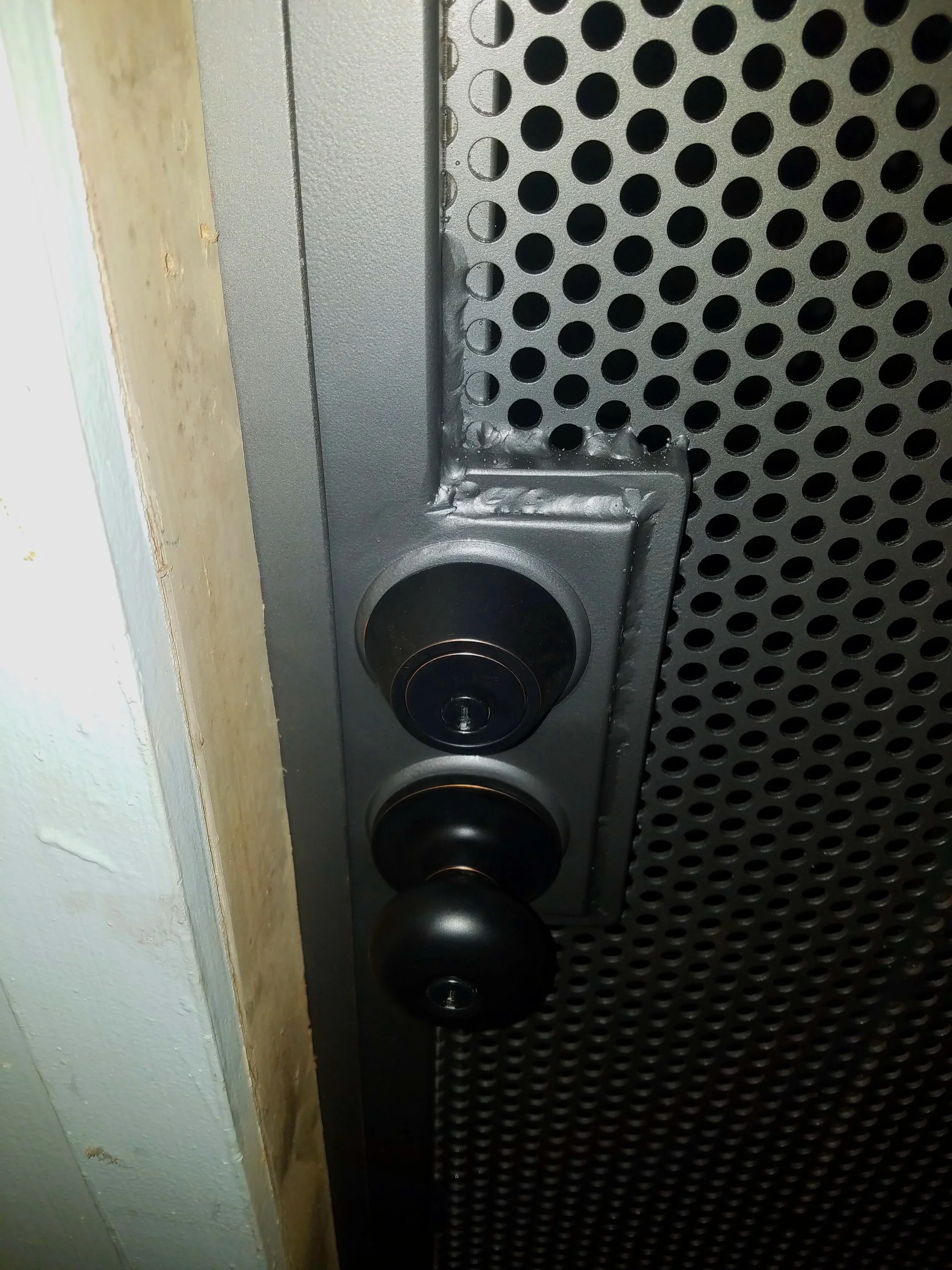 Close-up of an outdoor gate deadbolt and door handle.