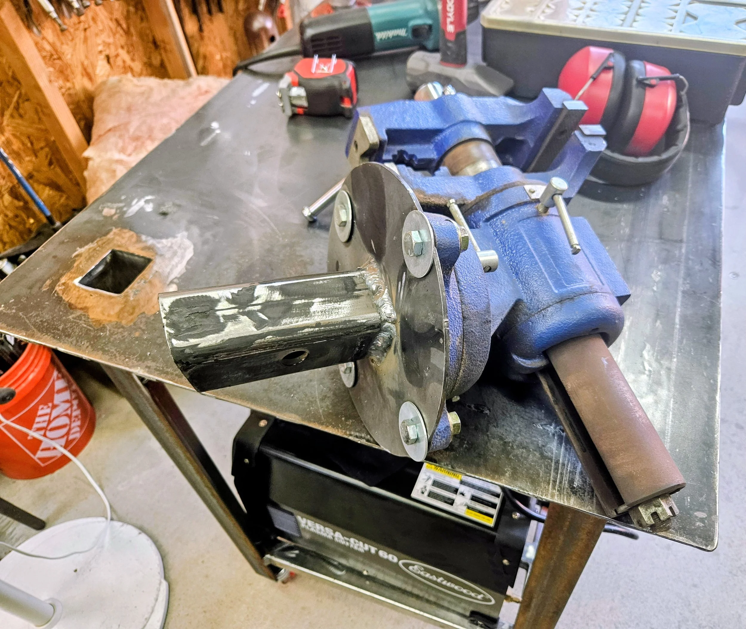Cut out an 8" circle with my Plasma Torch and welded the male hitch to the center then mounted a Vise to it, now it easily installs into the Table.  
