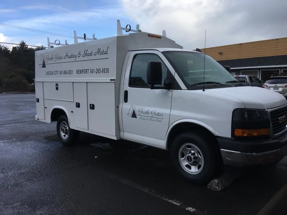A white service utility truck parked in a lot, with signage on the side for Groth Gates Heating & Sheet Metal.