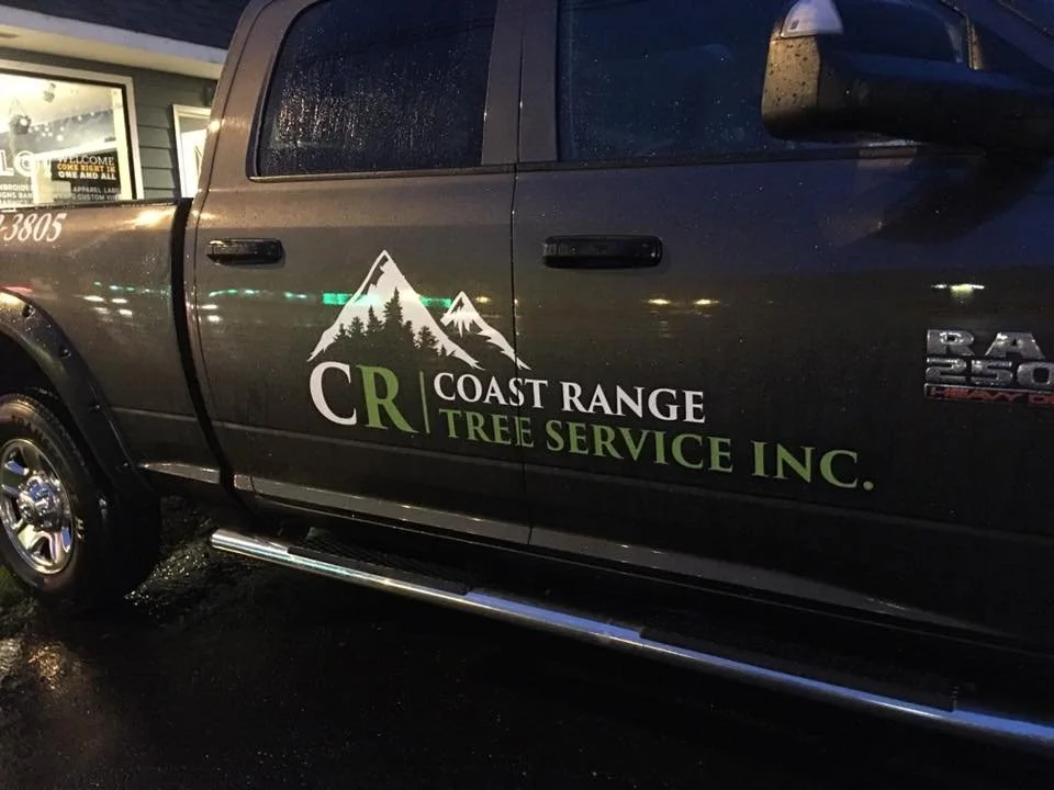 Black pickup truck with a logo reading 'CR Coast Range Tree Service Inc.' and a graphic of mountains and trees on the door.