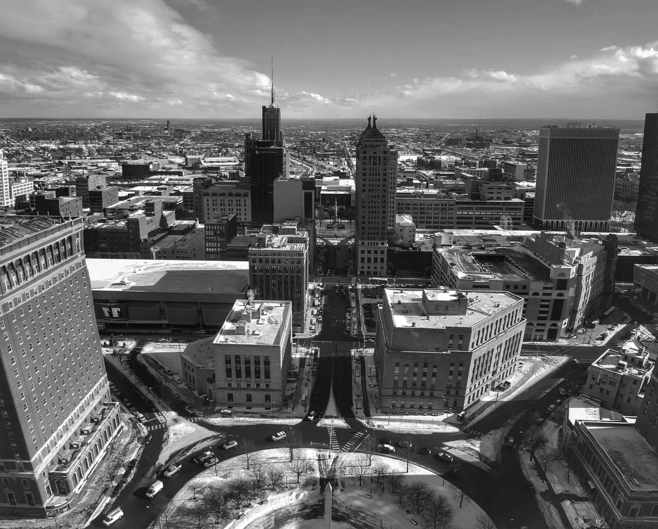 Black and white aerial view of downtown Buffalo, NY with Buffalo City Hall, Niagara Square , and snow on ground.