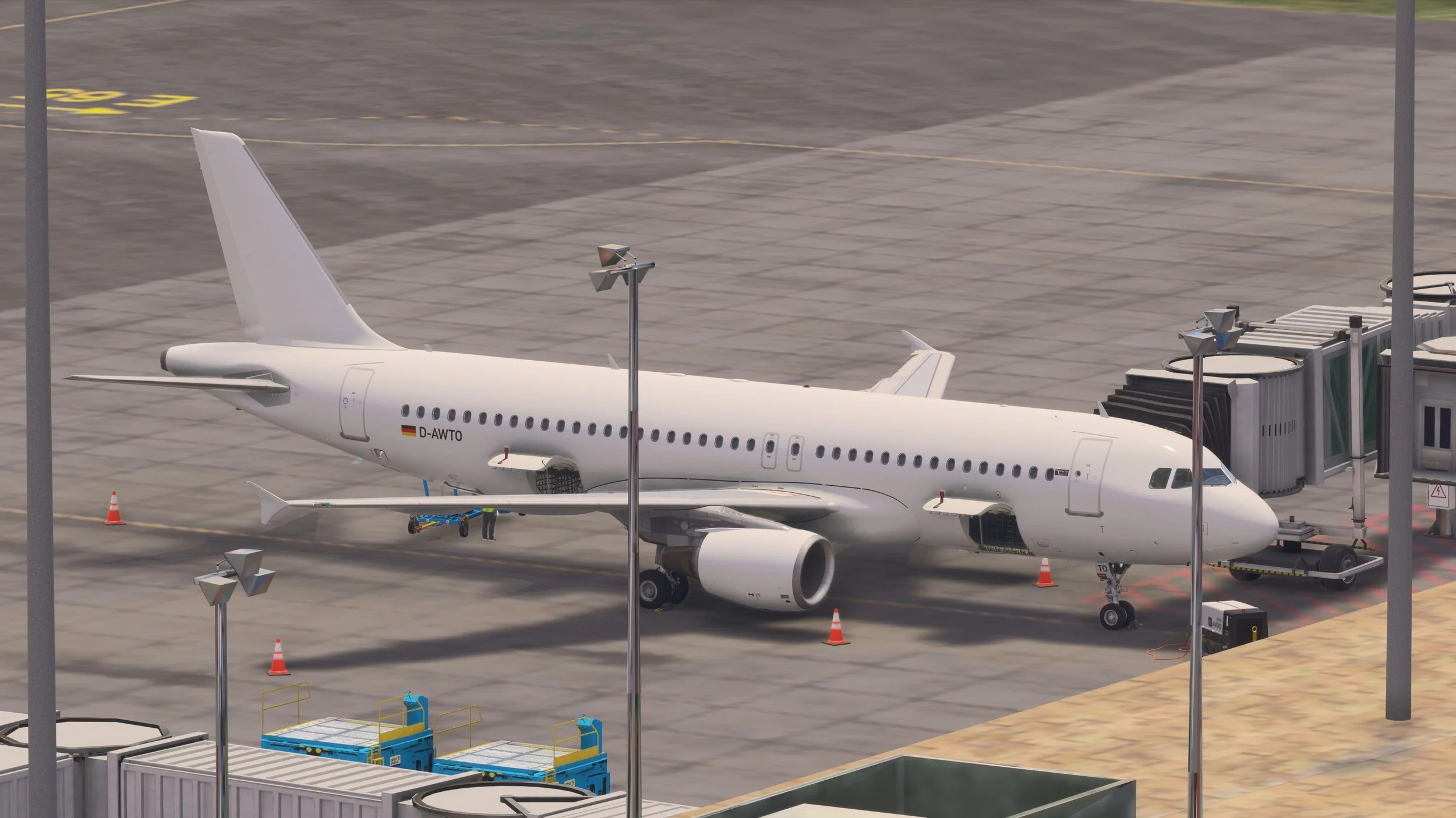A white commercial airplane parked at a gate at an airport, connected to a jet bridge, with various ground support equipment nearby.