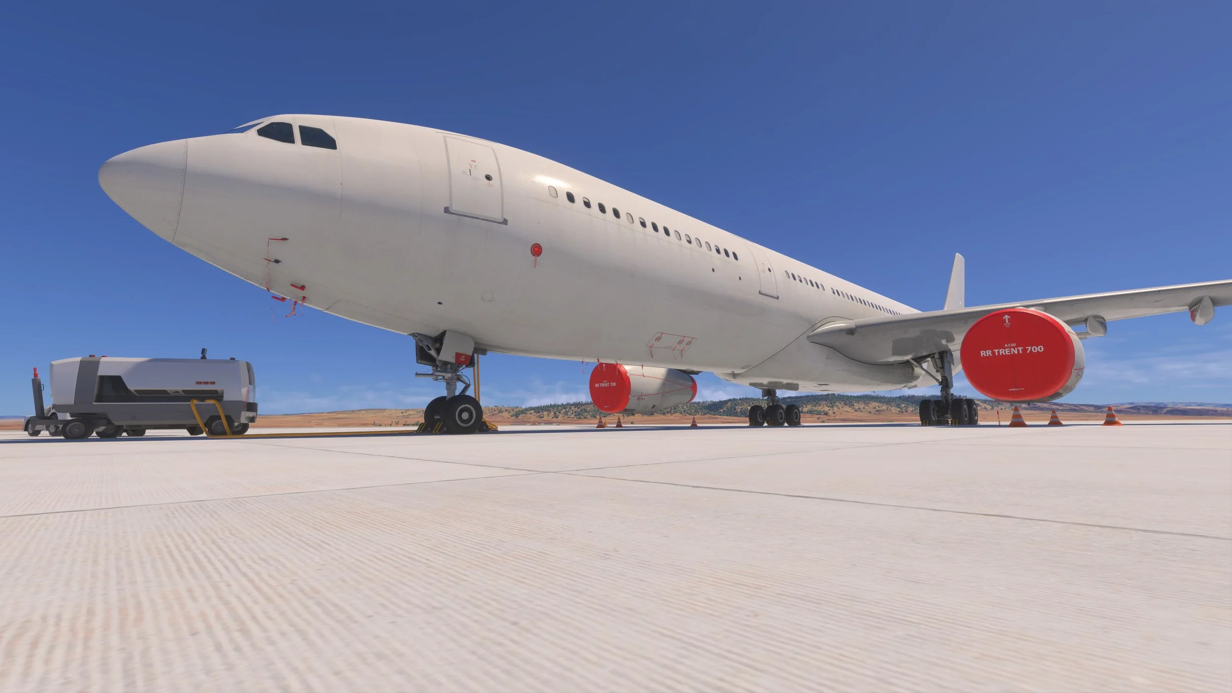 A large commercial airplane on the tarmac with maintenance equipment nearby, set against a clear blue sky and distant desert landscape.