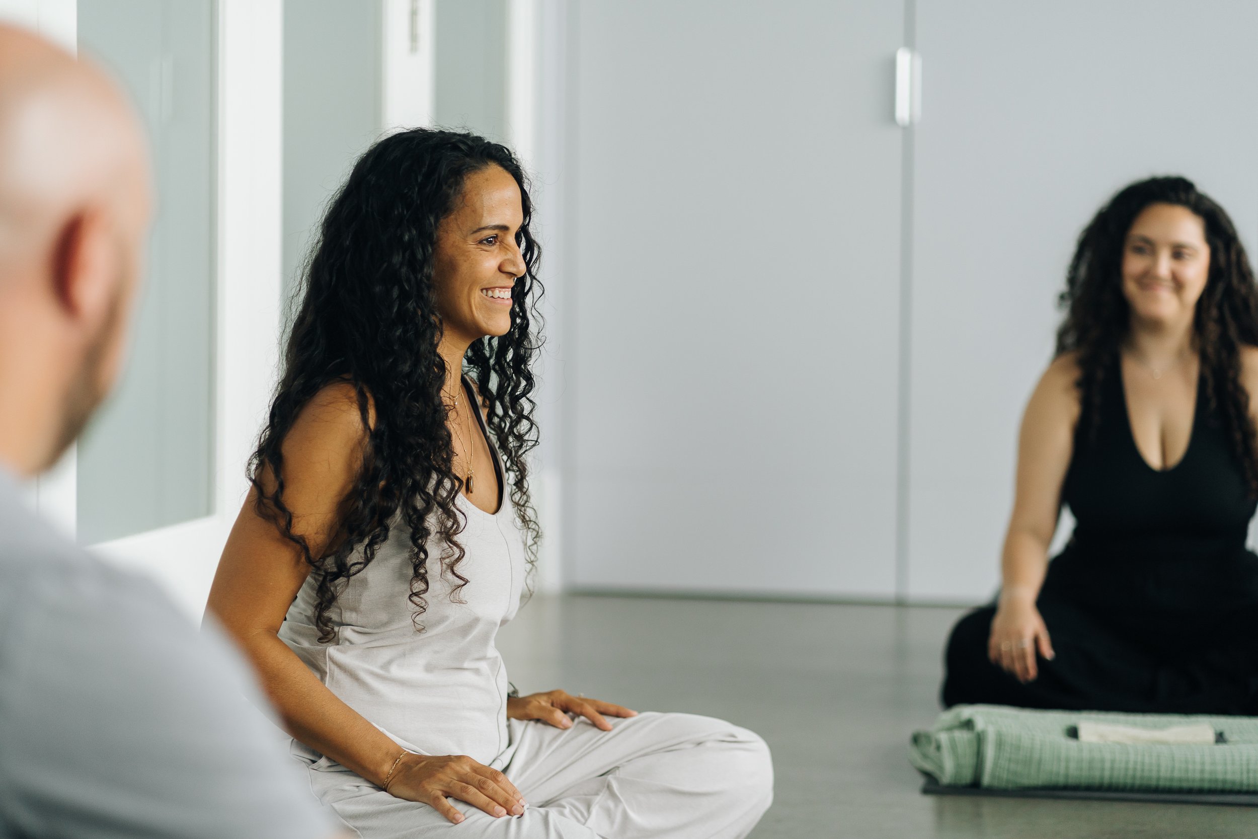 Sunshine sitting with a group of people before beginning a breathwork session, smiling and engaging with each other.