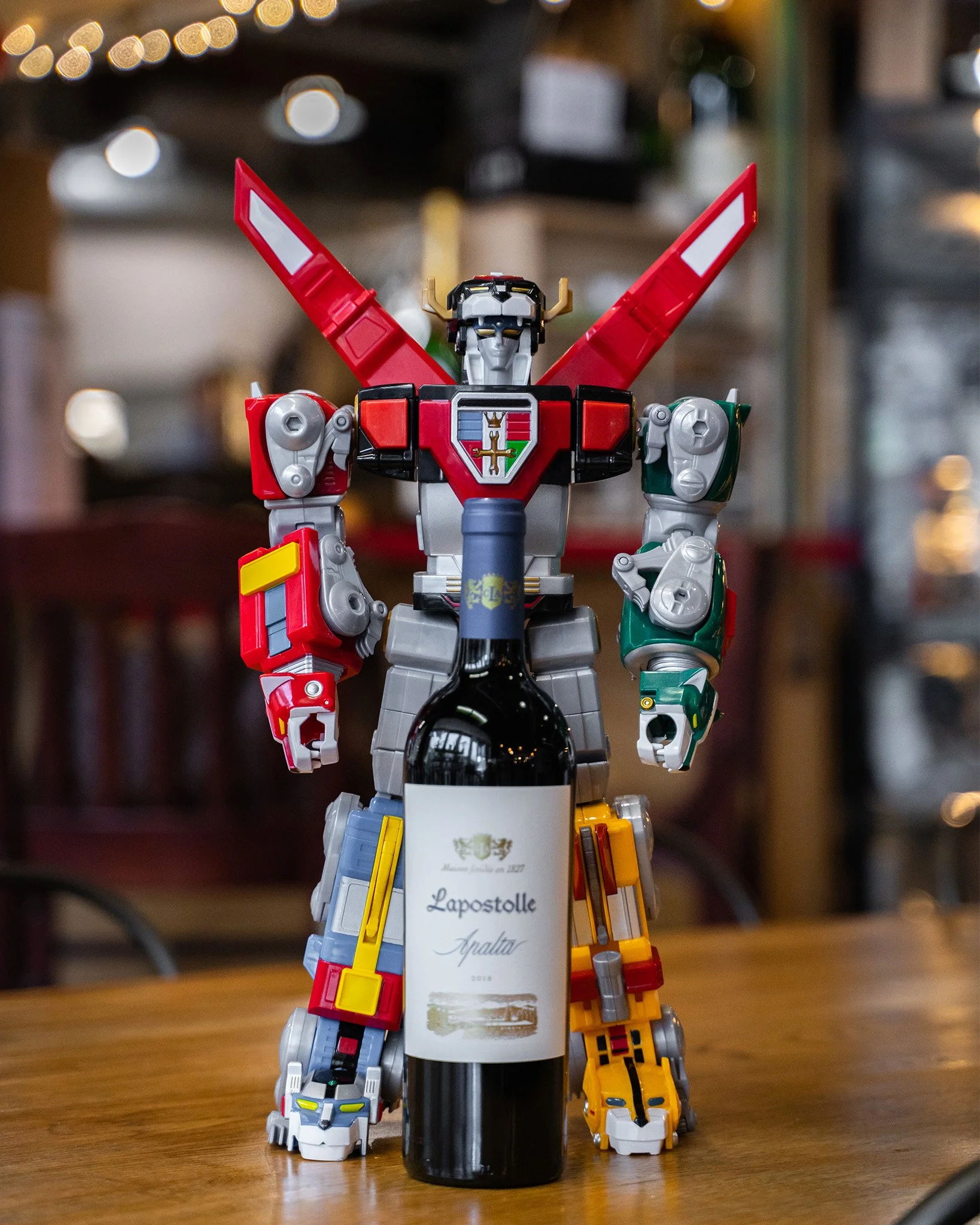 A bottle of wine positioned in front of a mech robot.