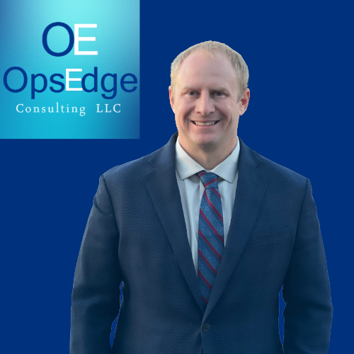 Professional Consultant smiling in front of a logo that says, "OE OpsEdge Consulting LLC."