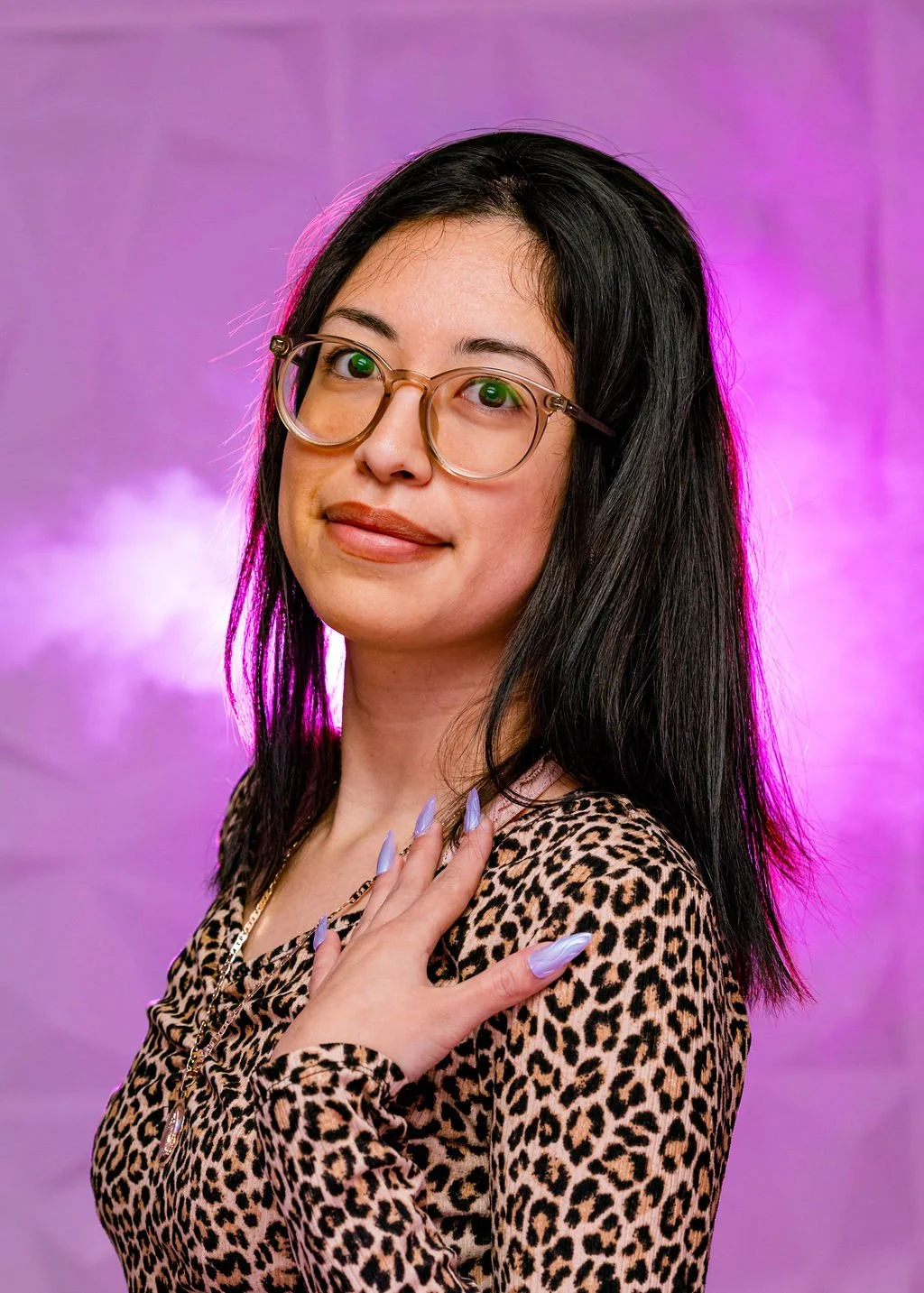 Headshot of Daniela turning toward the camera and showing her nails