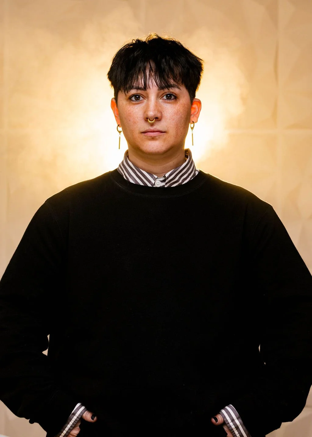 Headshot of Sunny wearing a black sweater and a soft beige background