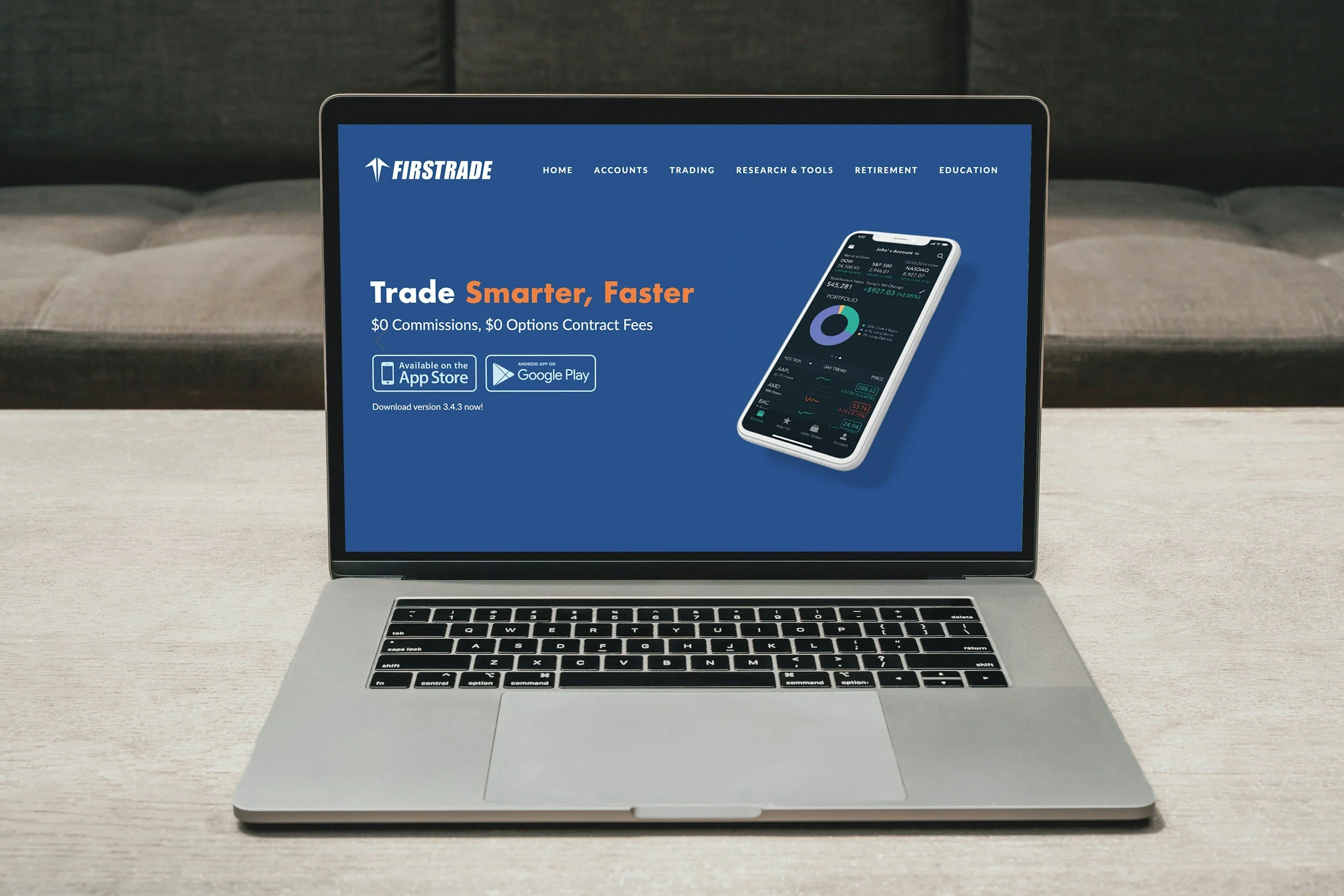 Écran d'ordinateur portable affichant le site web de la plateforme de trading Firstrade, avec le slogan 'Trade Smarter, Faster' et des icônes pour télécharger l'application sur l'App Store et Google Play.