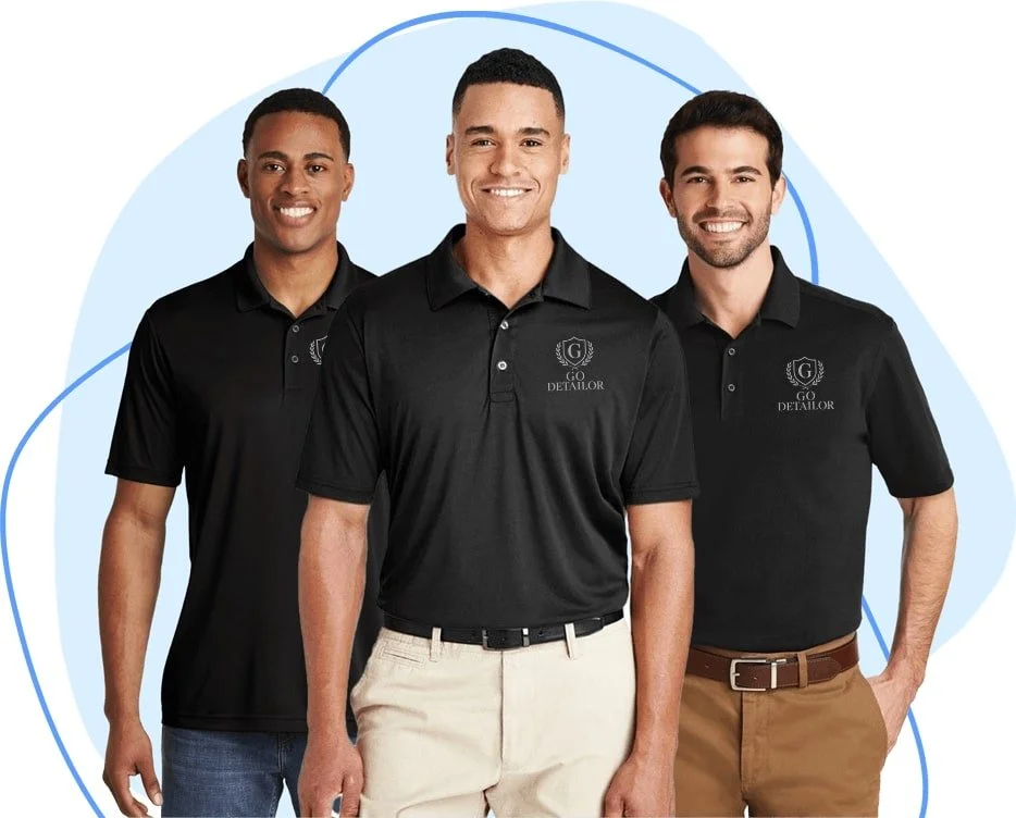 Three men standing together in black polo shirts with a logo that reads 'Go Detailor,' smiling at the camera, with a light blue abstract background.