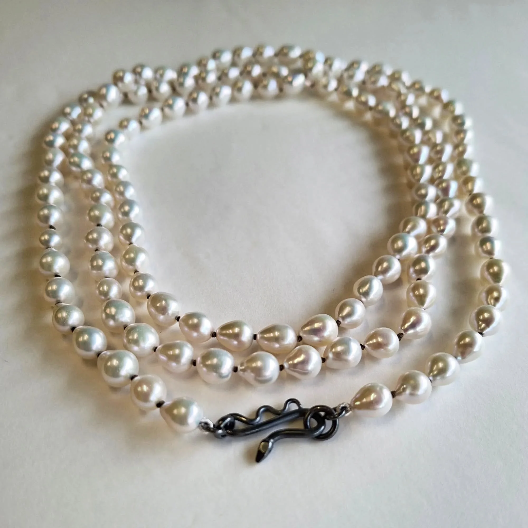 The finished fresh water pearl strand. 130 ish cms long, can be worn long, or doubled or tripled, knotted on bronze toned cord, with a handmade sterling silver tuna catch. 
I'll be putting some of these on my website next week (if they don't sell in 