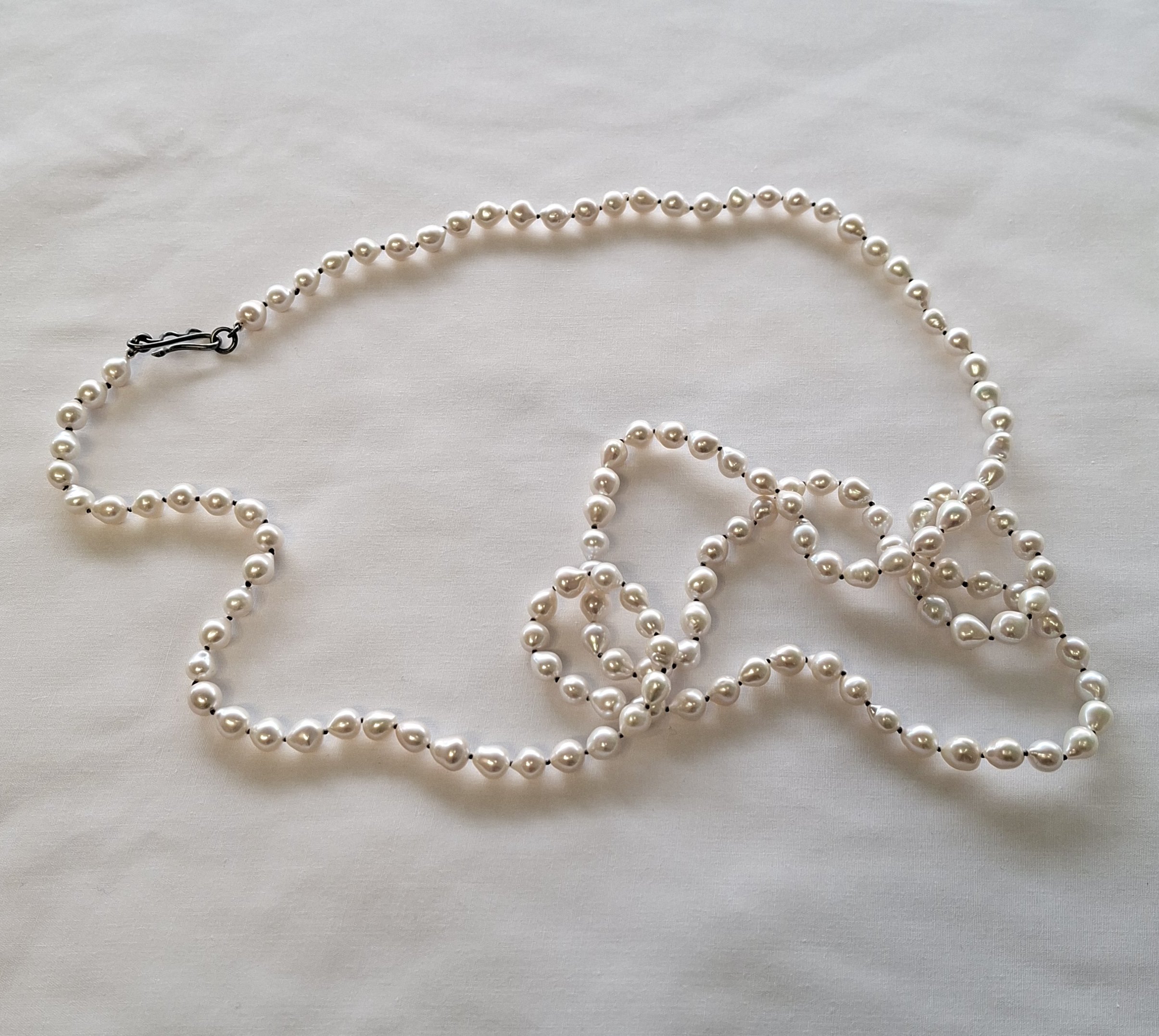 Teardrop shaped pearl strand. (beige thread)