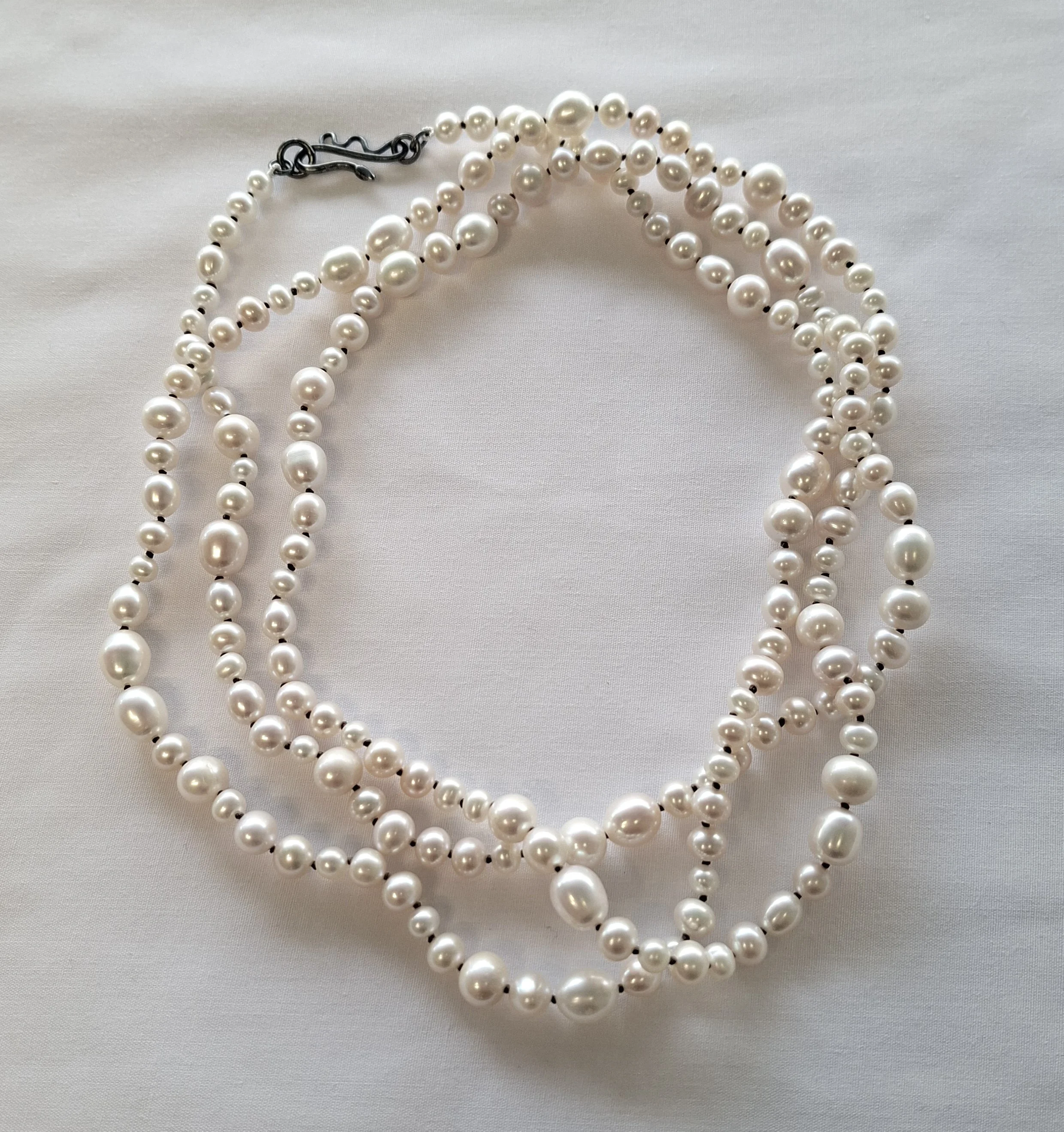 Bubbles. Pearl strand, white on beige.