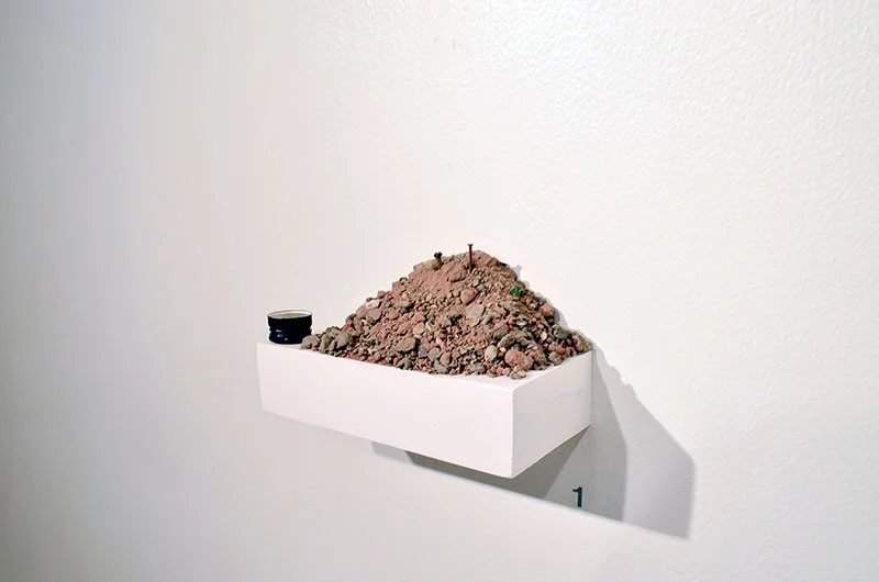 Space Cookie Mountain - Collaborative work - debris collected by sweeping Luis Street, Woodbrook, Port of Spain, and rum cork installed on shelf, size variable.