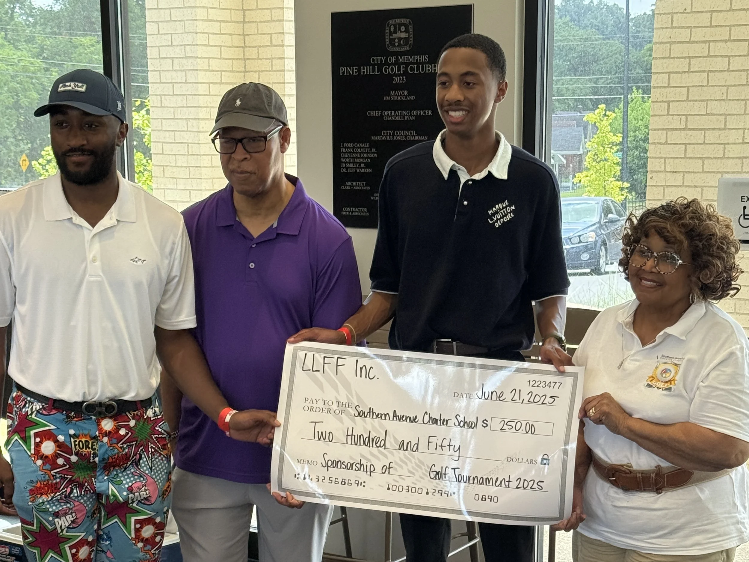 Four people standing indoors, holding a large check made out to Southern Avenue Charter School for $250.00, dated June 21, 2025, from LLFF Inc., during a donation or sponsorship event.