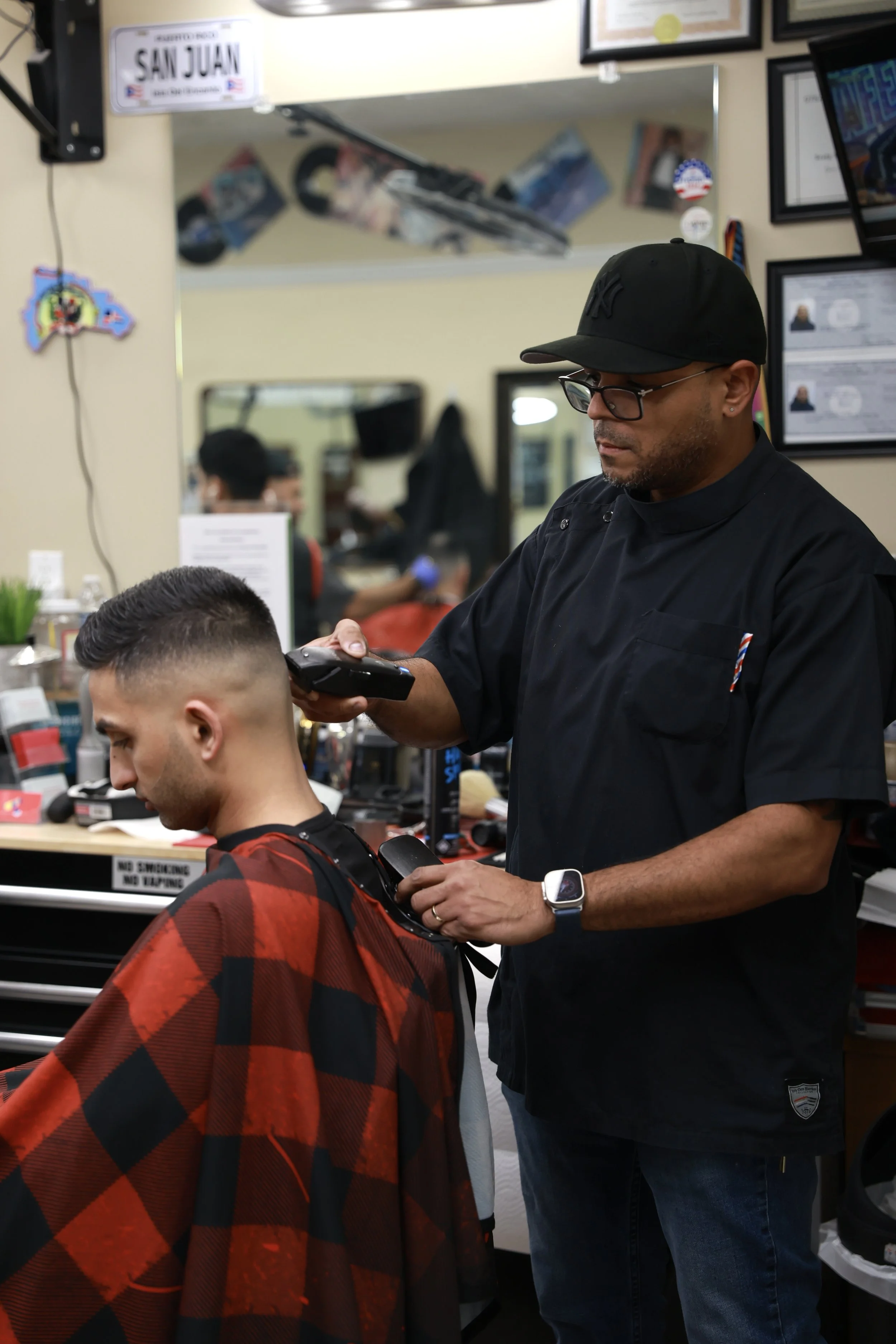 Barber trimming a young man's hair in a barbershop