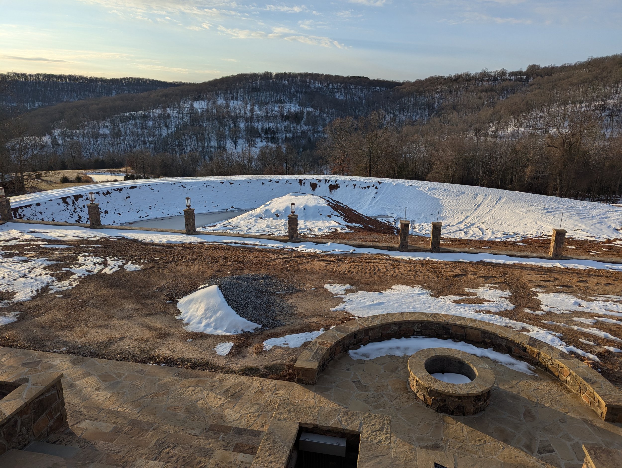 In progress pond with island, rock firepit