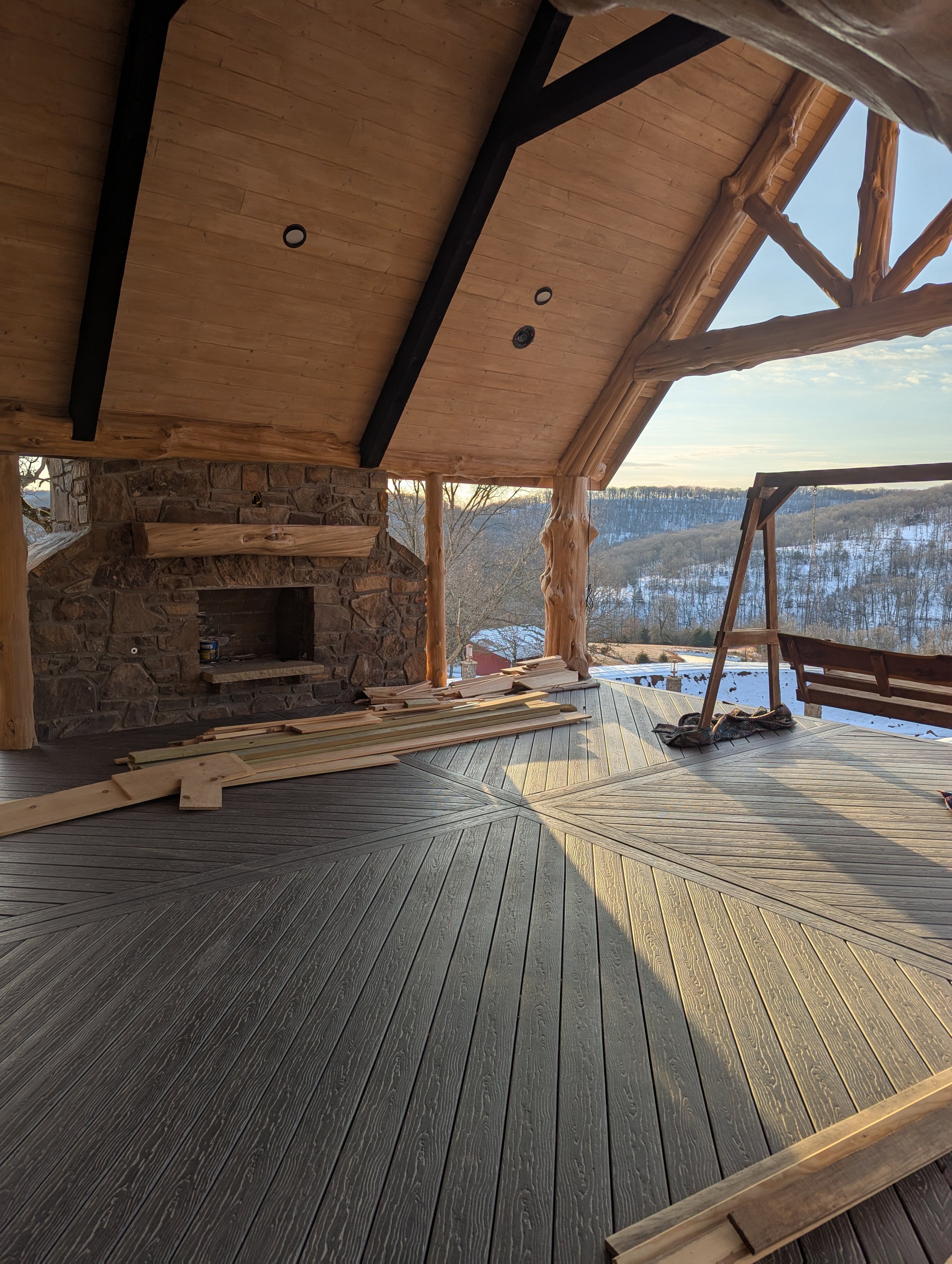 Rock fireplace, composite decking, cedar log trim