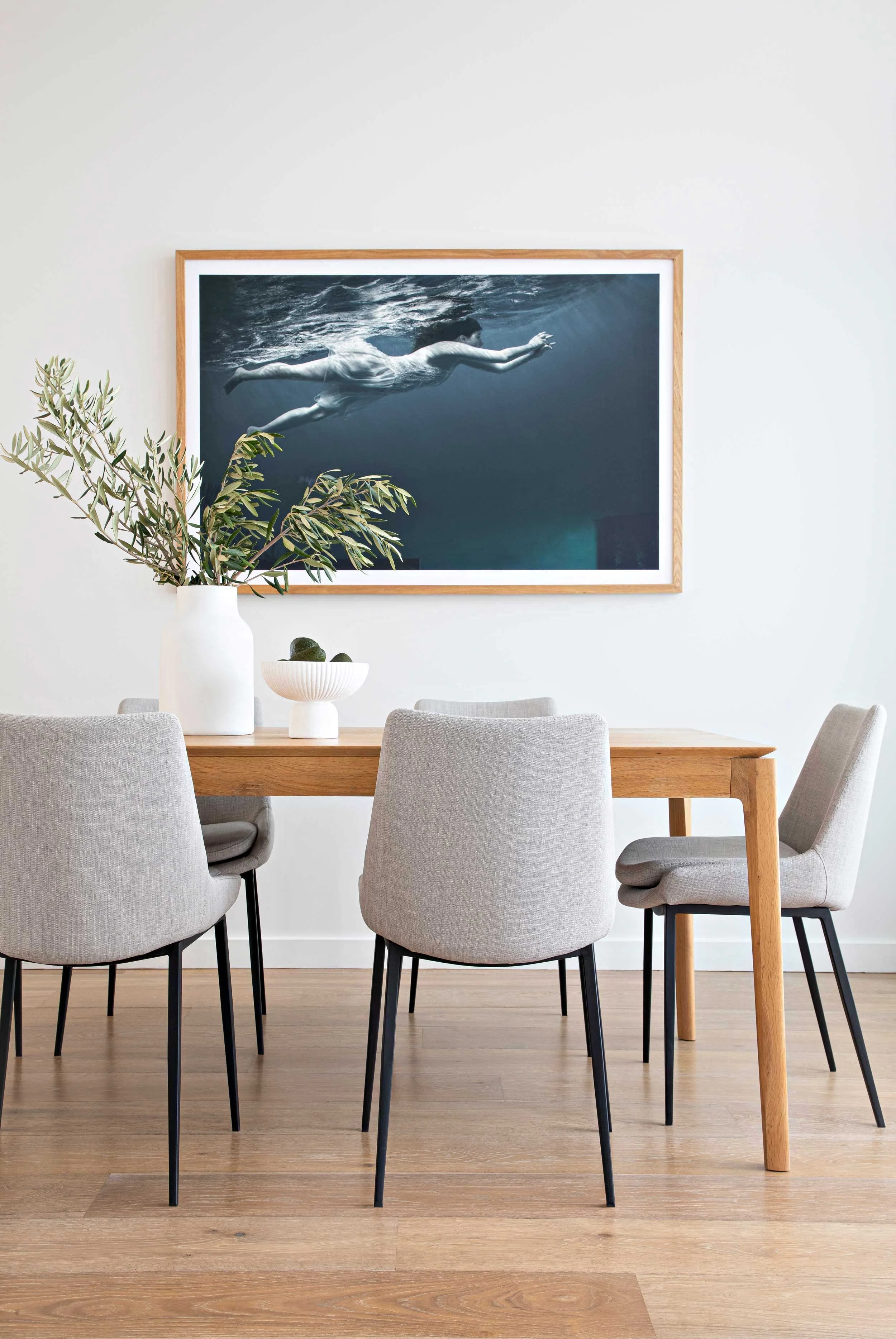 Dining setting with wood table white chairs & wall artwork NSW South Coast