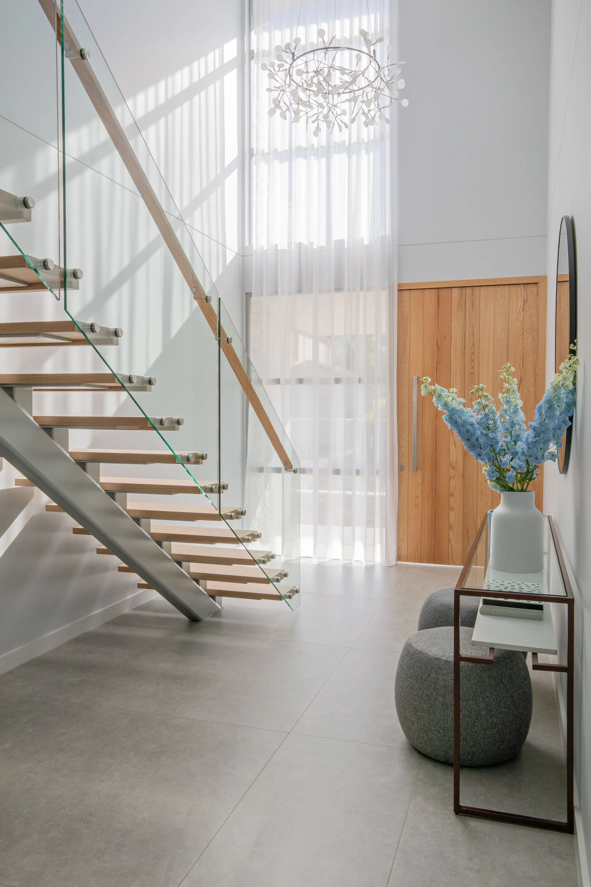High ceilinged house front entrance modern stairway side table