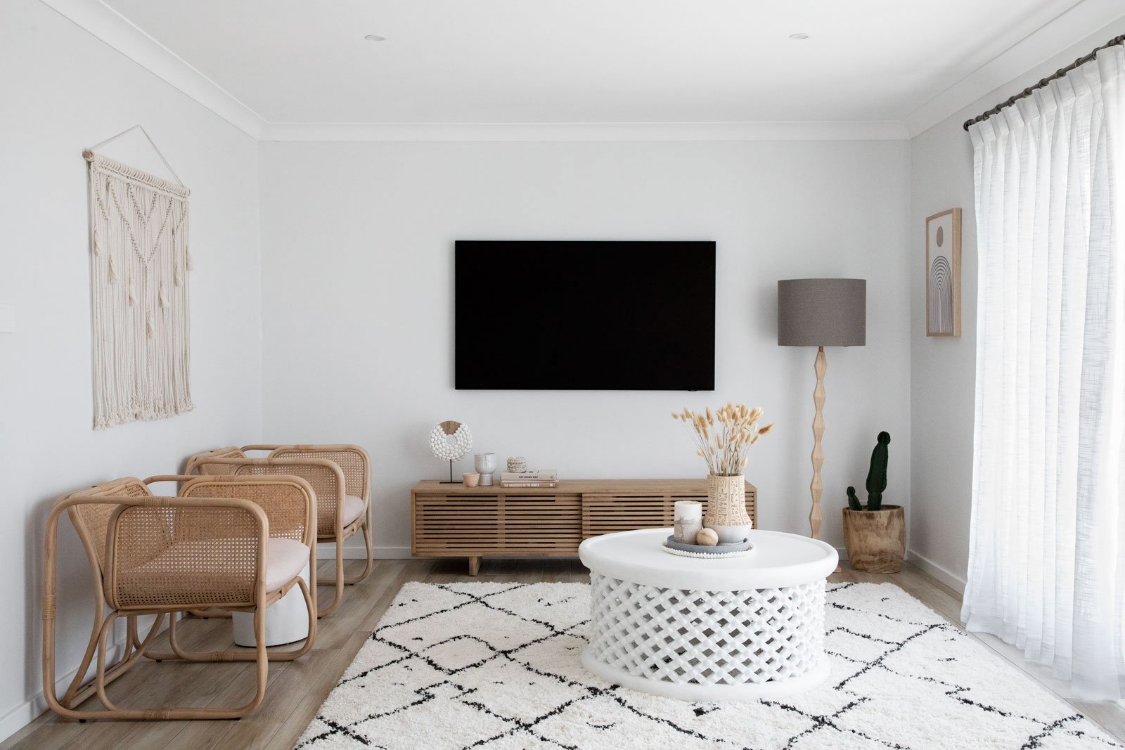 Living room cane chairs white coffee table wall television white rug NSW South Coast