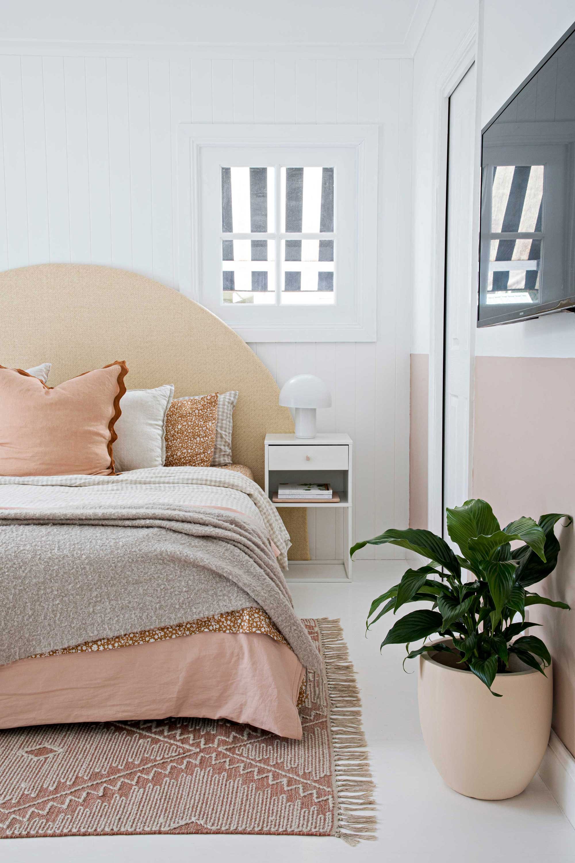Interior styled bedroom arched bedhead cushions throw rug floor rug pot plant