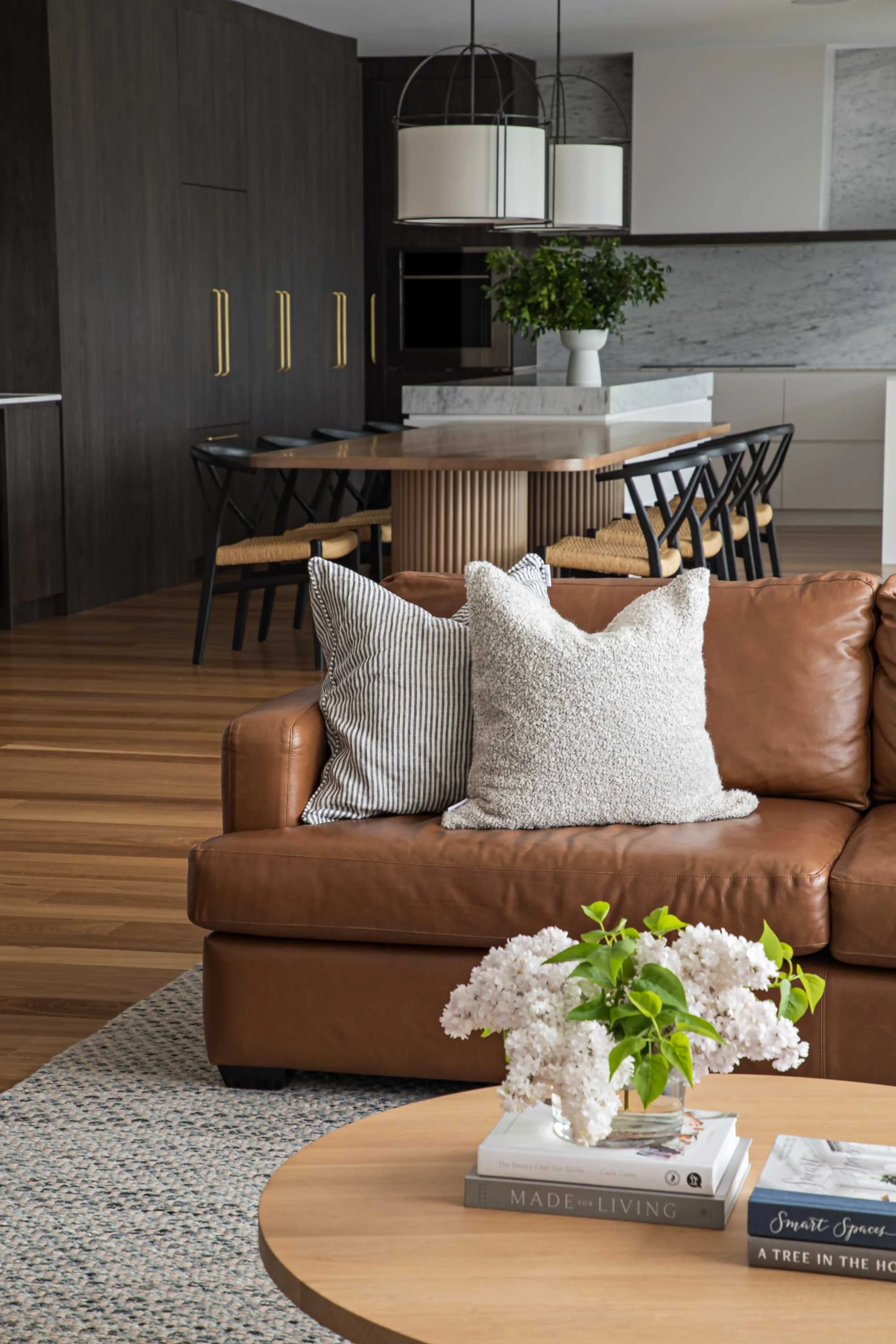 Sydney designer kitchen living area dark cupboards leather lounge round coffee table