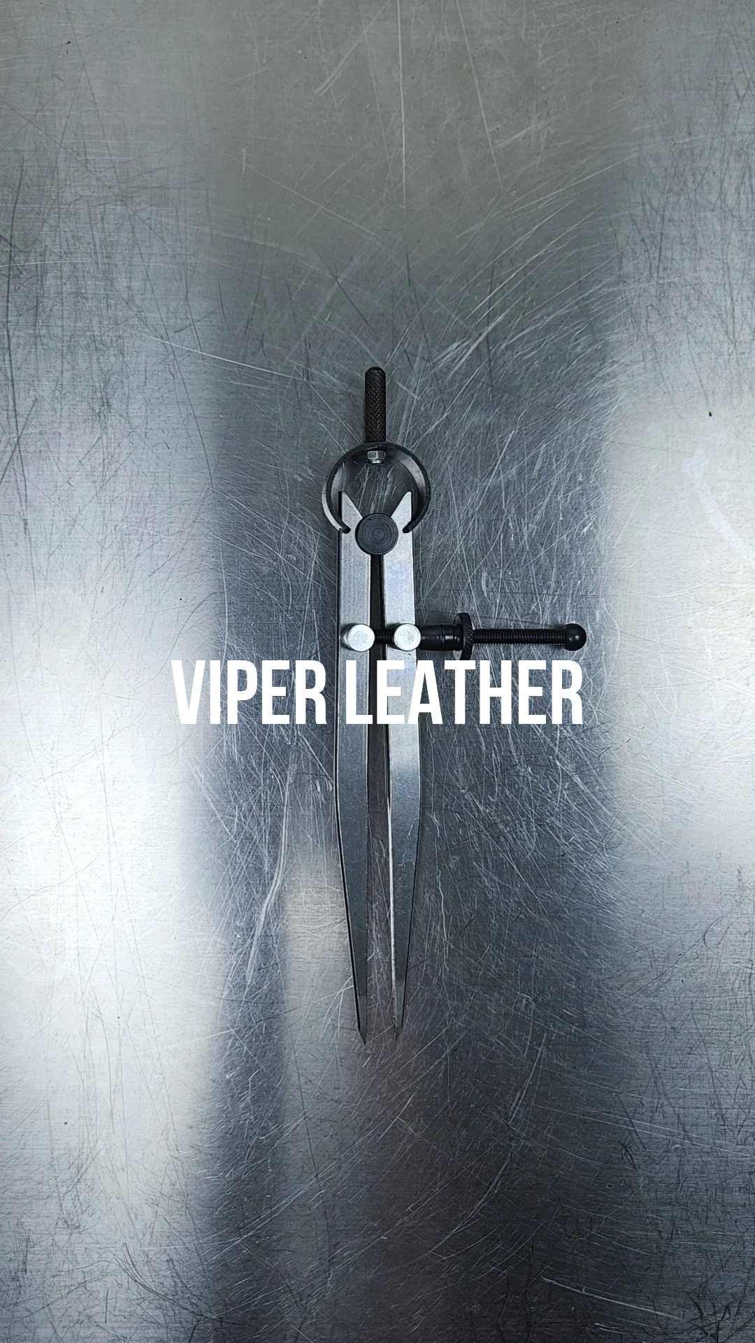 A pair of metal dividers on a scratched stainless steel surface with the text 'VIPER LEATHER' overlaid.