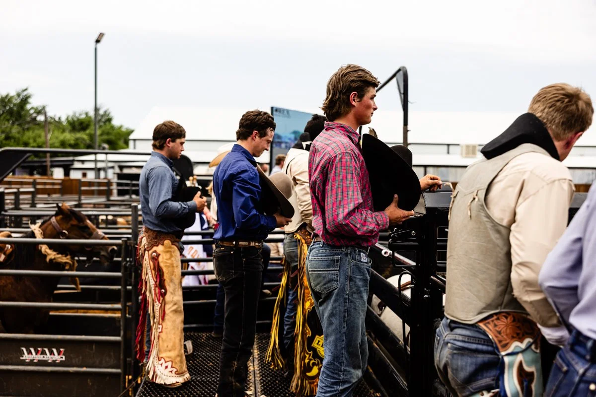 Cowboys remove their hats and bow thier heads during a prayer before a rodeo.