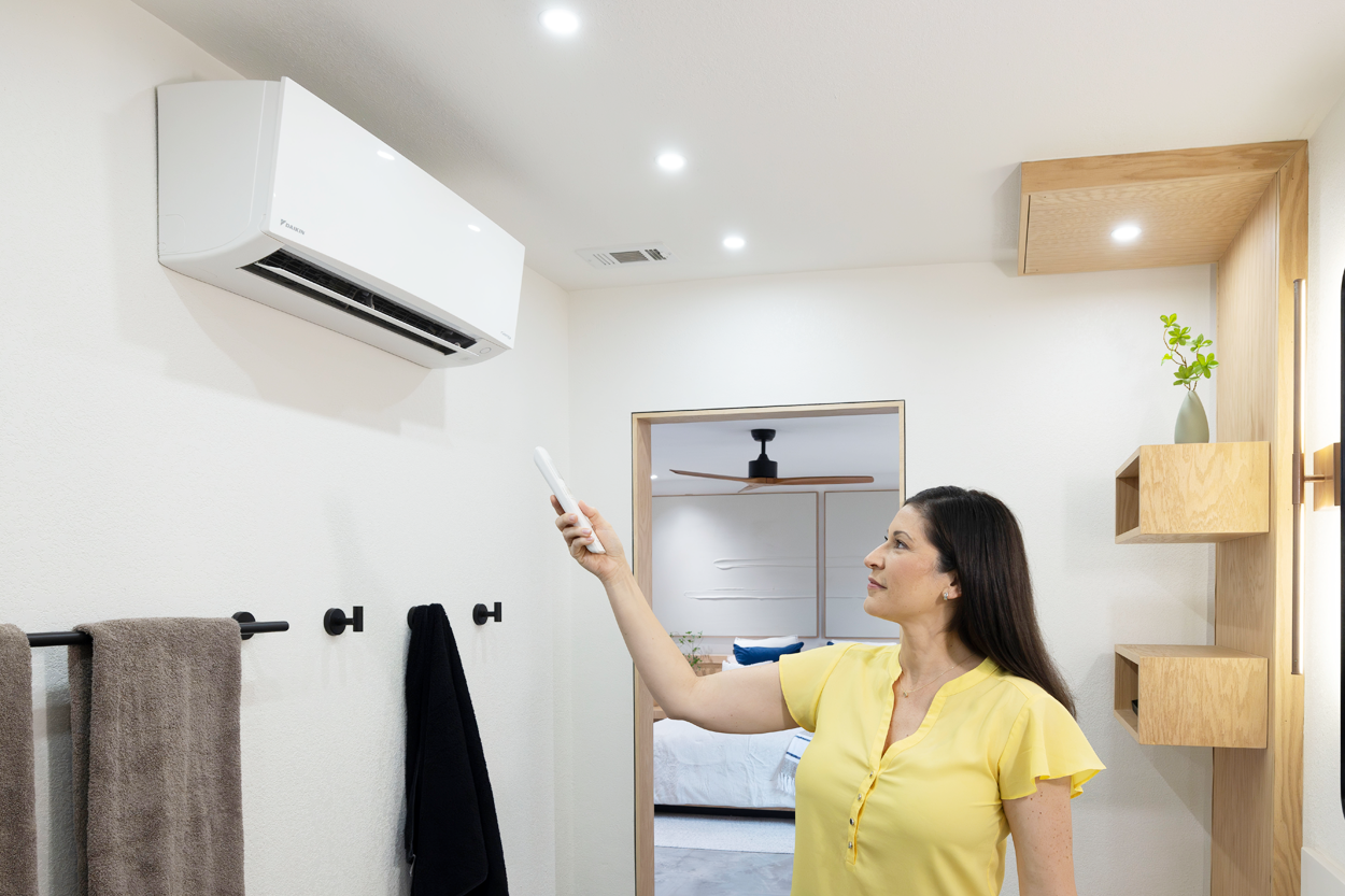 Woman using remote for Daikin Ductless Mini Split HVAC in Bakerfield