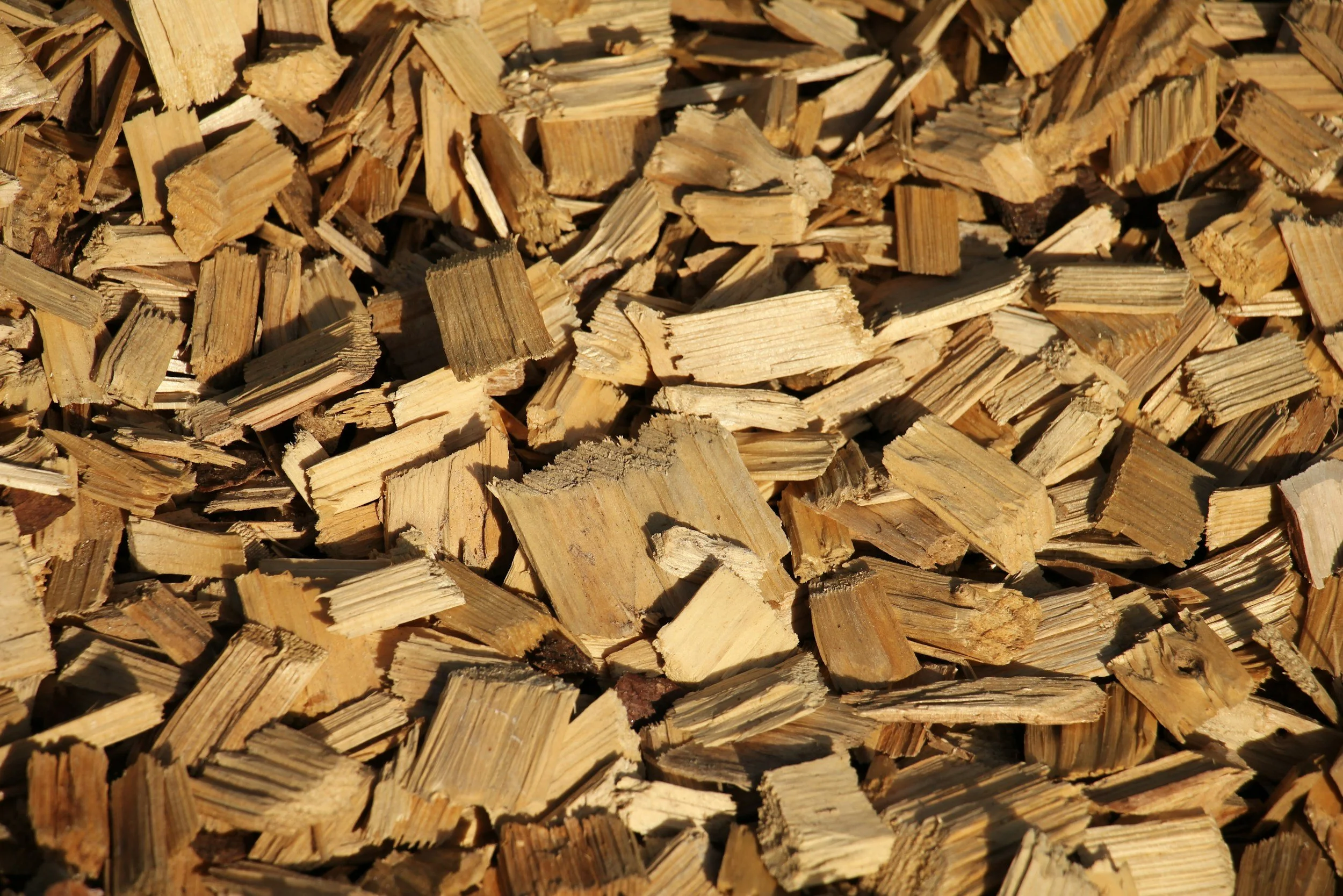 A close-up of a large pile of chopped wood pieces stacked together.